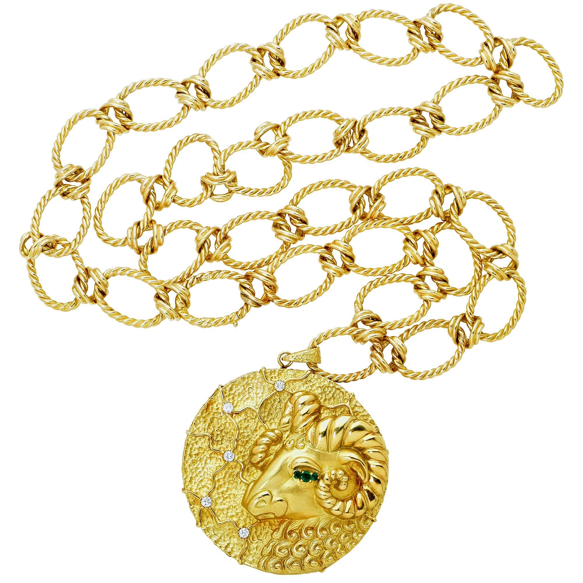 18K yellow gold necklace with a ram's head motif containing 5 round brilliant cut diamonds weighing approxiately .90cts F color and VS clarity, as well as 3 round cut emeralds weighing approximately .20cts. This unique necklace is signed