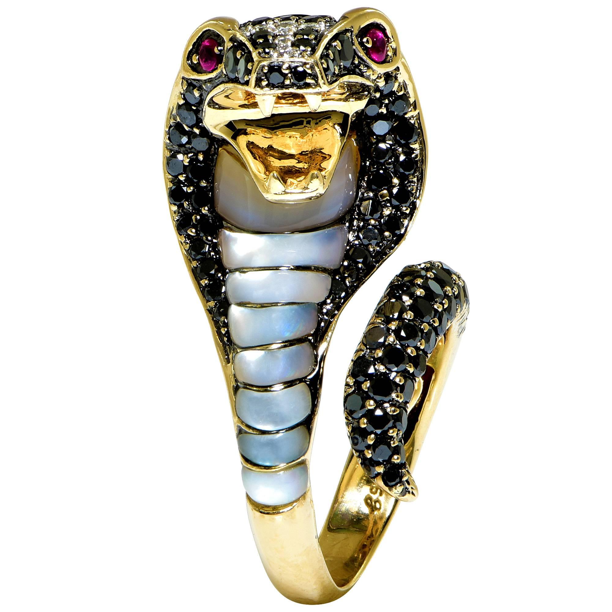 14k yellow gold ring featuinrg a cobra snake accented with inlaid abalone and mother of pearl, highlighted by approximately 3cts of black and white diamonds and ruby eyes.

The ring is a size 7 and can be sized up or down. It measures 1.40 inches in
