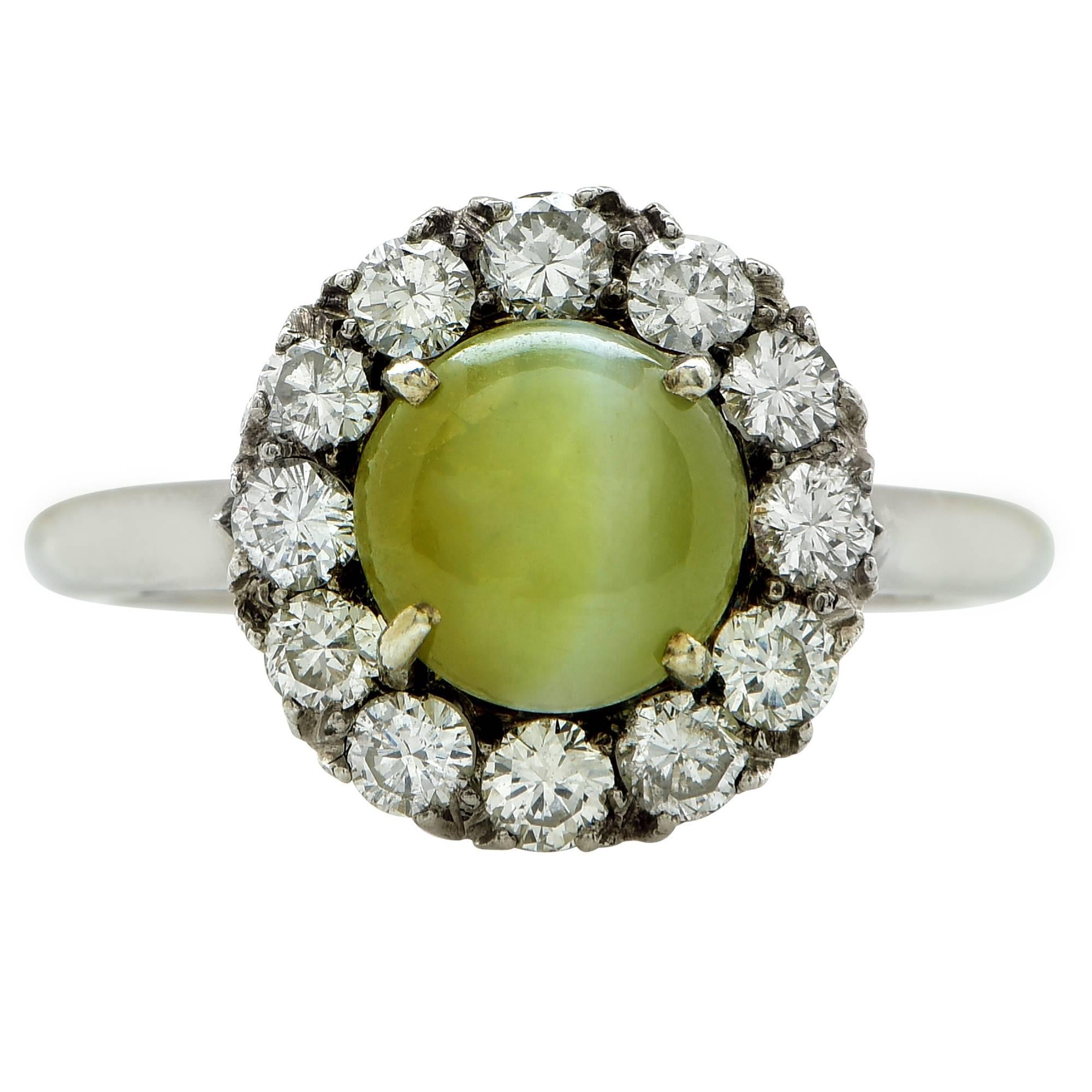 18k white gold ring featuring a cabochon cut cats-eye chrysoberyl weighing approximately 2.5cts total, accented by 12 round brilliant cut diamonds weighing approximately .70cts total G color VS clarity.

The ring is a size 5.75 and can be sized up