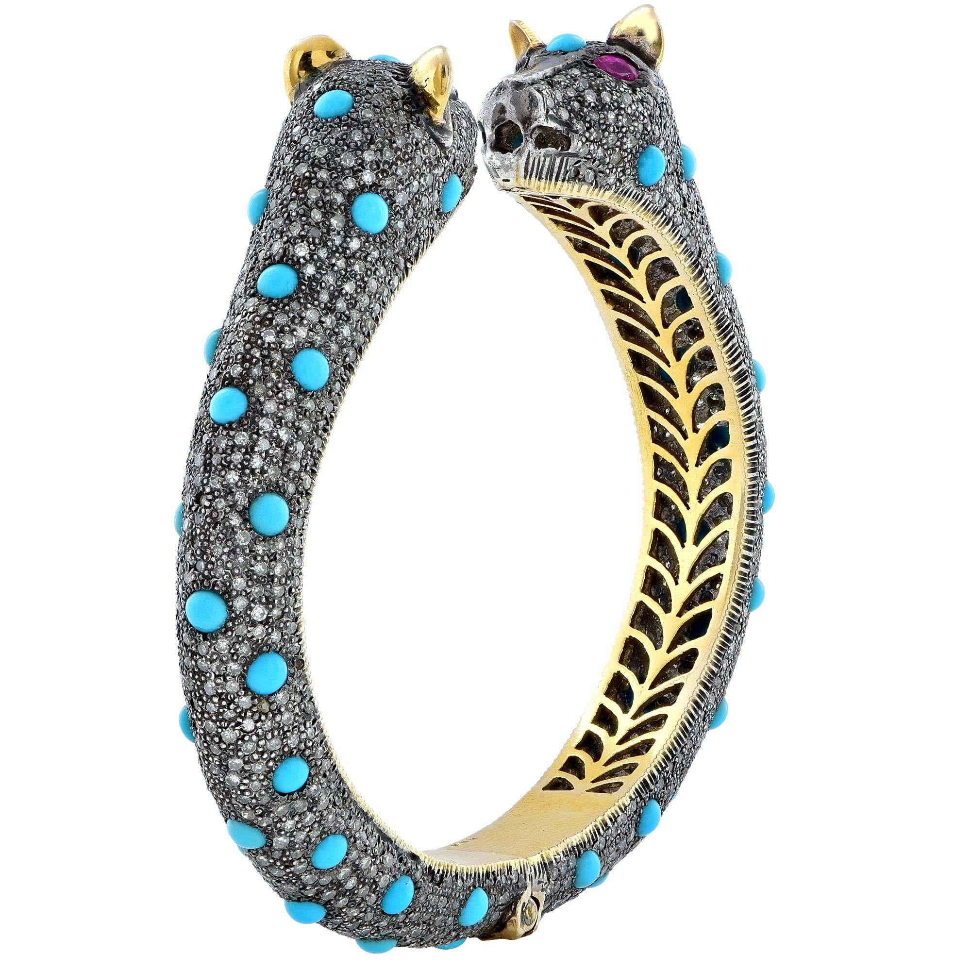 Silver and 14k yellow gold double headed lion bangle featuring diamonds and turquoise.

The bracelet measures 6.25 inches in circumference by .50 inch in width.
It is stamped and/or tested as 18k gold.
The metal weight is 43.85 grams.

This