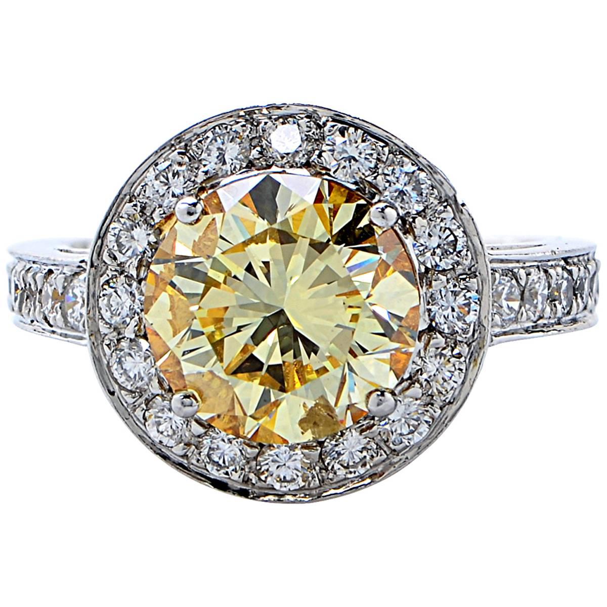 Beautiful handmade platinum engagement ring featuring a GIA graded 3.36ct fancy yellow round brilliant cut diamond accented by 52 round brilliant cut diamonds weighing approximately 1ct.

The ring is a size 6 and can be sized up or down.
It is