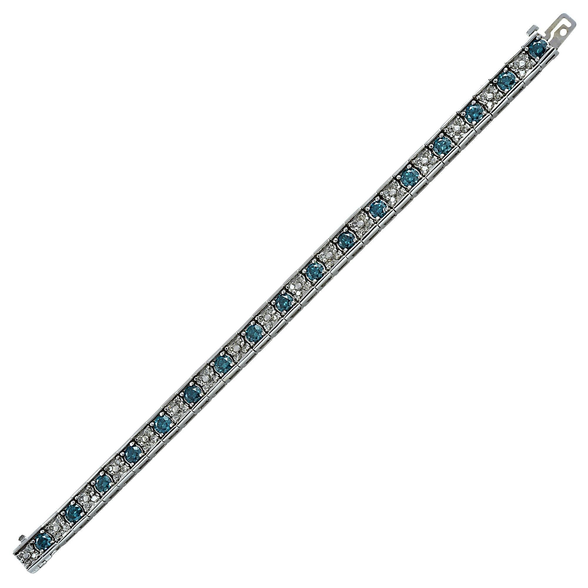 14k white gold bracelet containing 68 round brilliant cut diamonds weighing approximately 2cts H-J color and SI clarity, as well as 17 round brilliant cut irradiated blue diamonds weighing approximately 7cts.

This bracelet measures 7 inches in