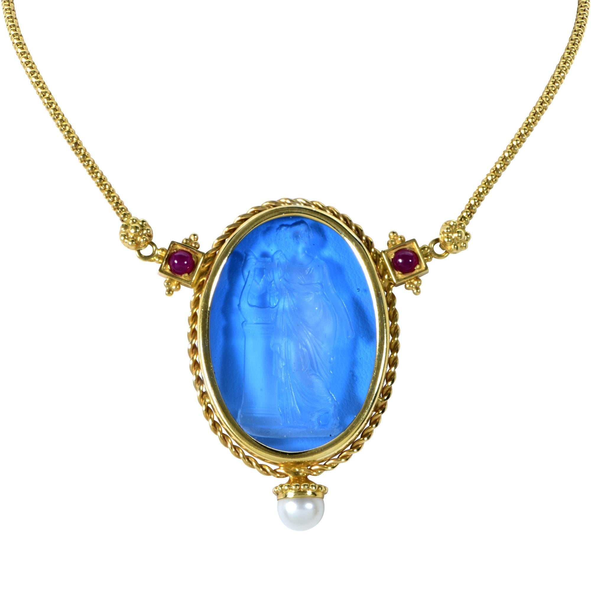 14k yellow gold necklace featuring a Venetian glass carving accented by pearls and rubies.

Measurements are available upon request.
It is stamped and/or tested as 18k gold.
The metal weight is 25.89 grams.

Our pieces are all accompanied by an