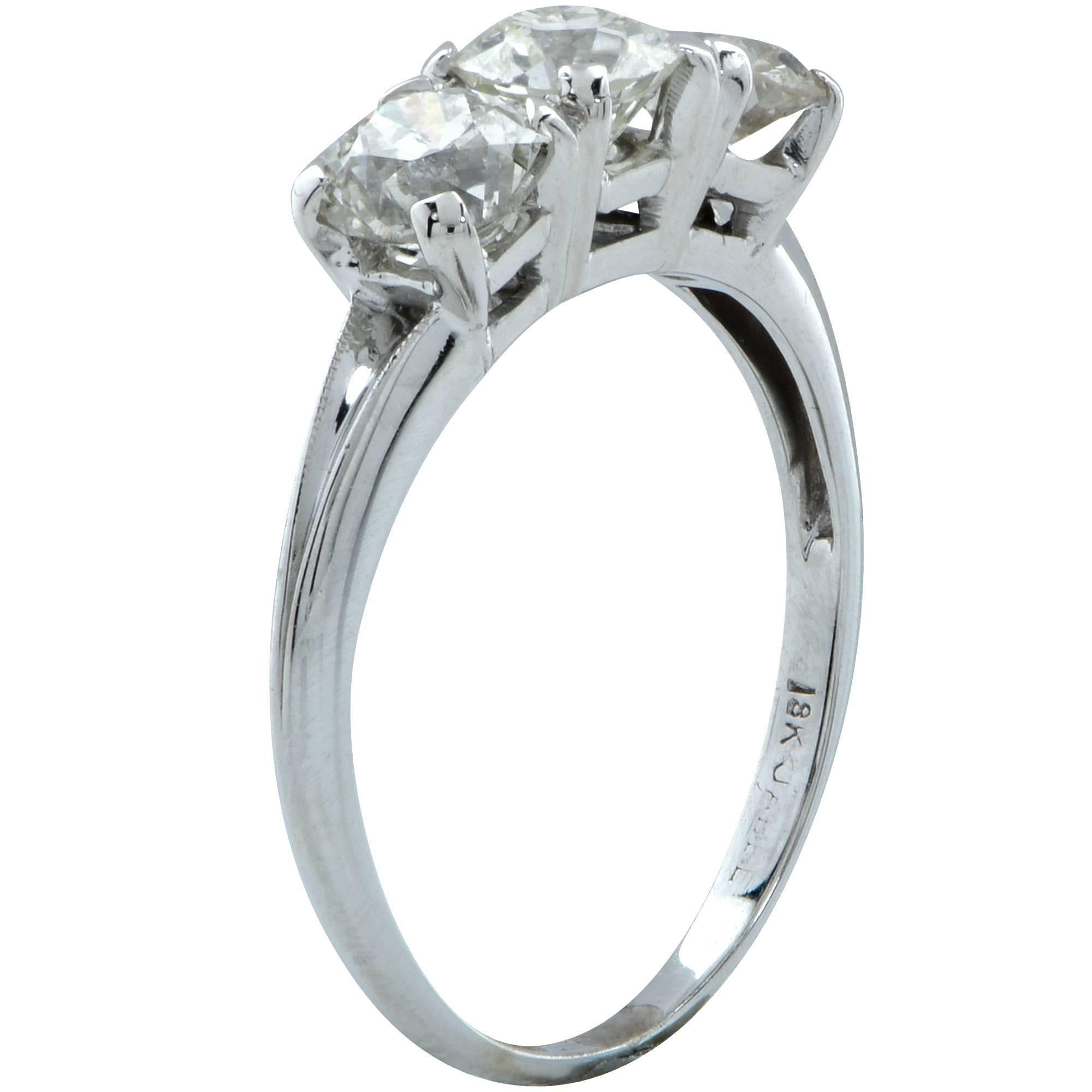18k white gold Art Deco three stone old European cut diamond ring featuring a .51ct old European cut diamond flanked by two old European cut diamonds weighing approximately one carat total, H-J color VS2- I1 clarity. The face of the ring measures