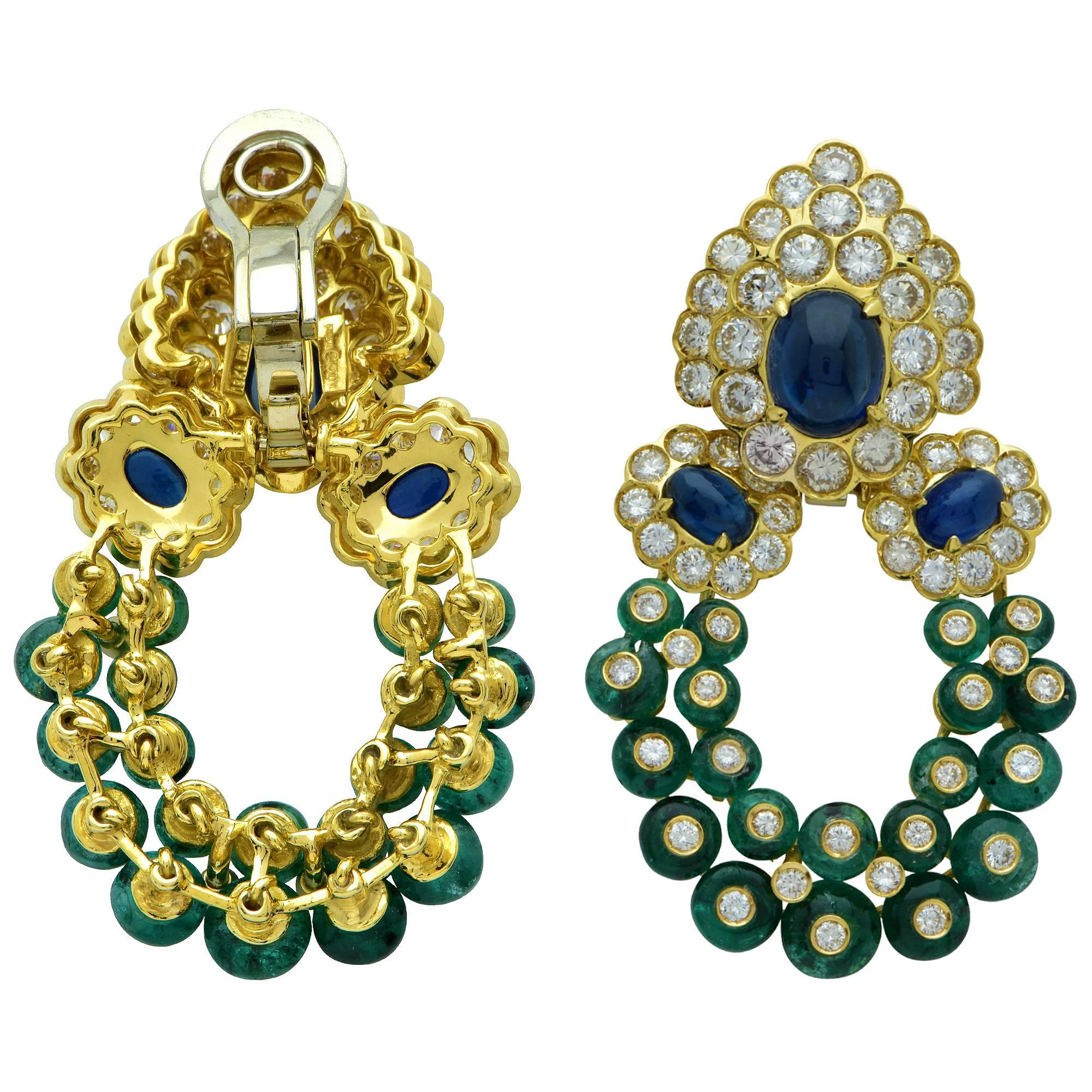 18k yellow gold dangle earrings signed Giovane featuring approximately 6.80cts of round brilliant cut diamonds G color VS clarity accented by sapphire cabochons and emeralds. The bottoms are removable and the earrings can be worn as