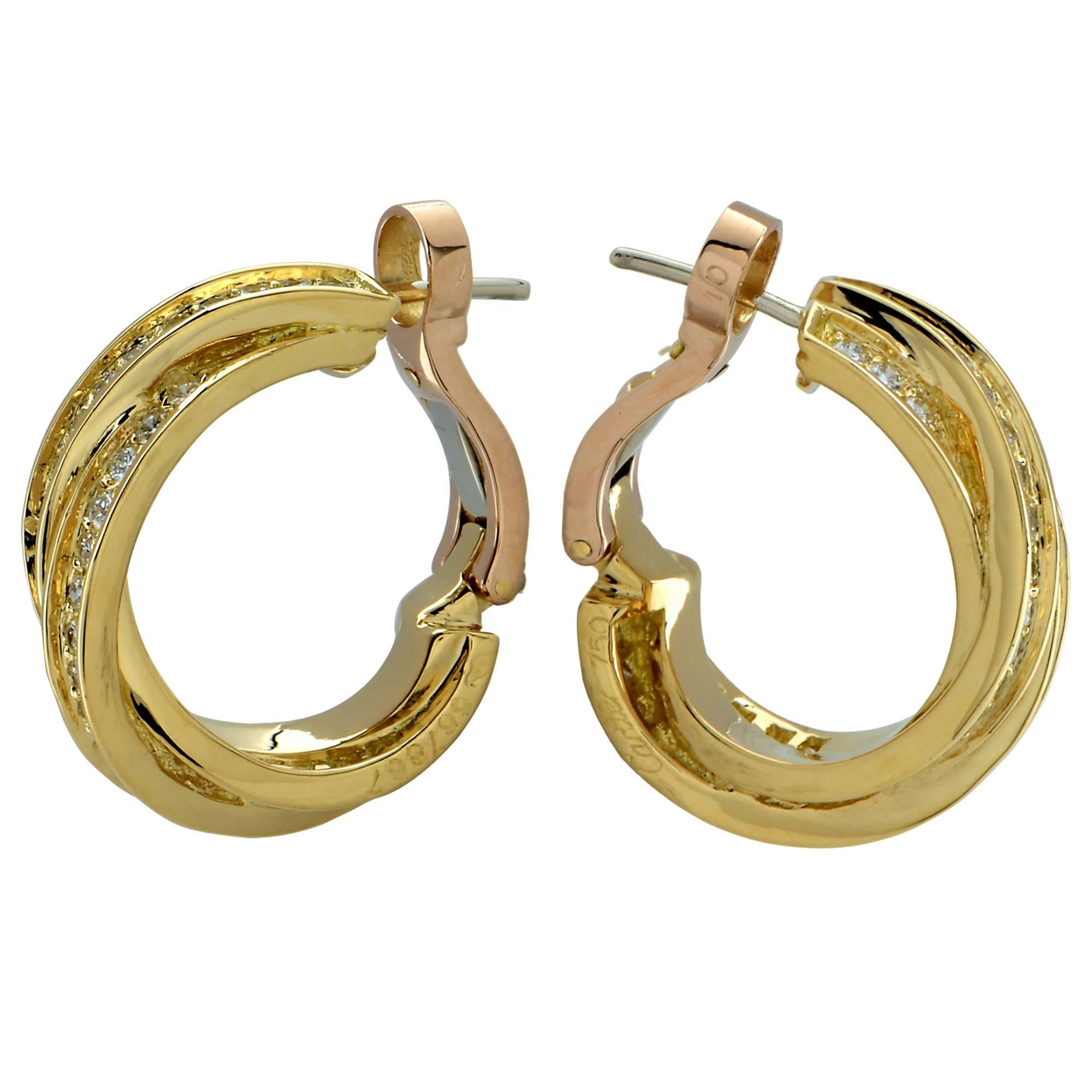 Classic Cartier 18k yellow gold and diamond earrings from the trinity collection featuring interlocking yellow gold hoops embellished with 92 round brilliant cut diamonds totaling approximately 1.4cts total F Color, VVS VS Clarity.  These gorgeous