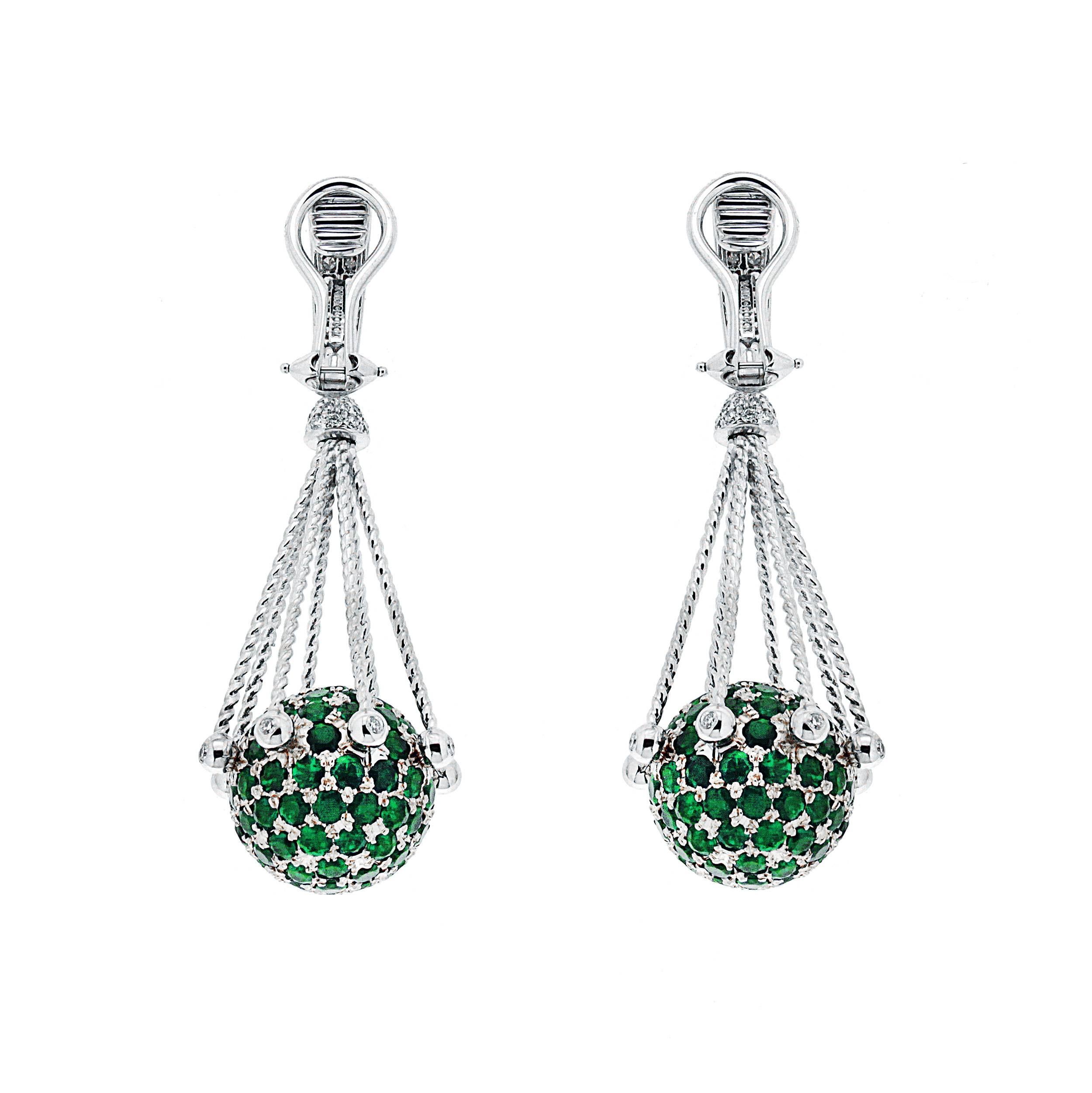 Each of these elegant dangling ball earrings features a pave emerald ball with diamond pave on the lever in 18 karat white gold. Clip backs (posts can be added on after purchase).