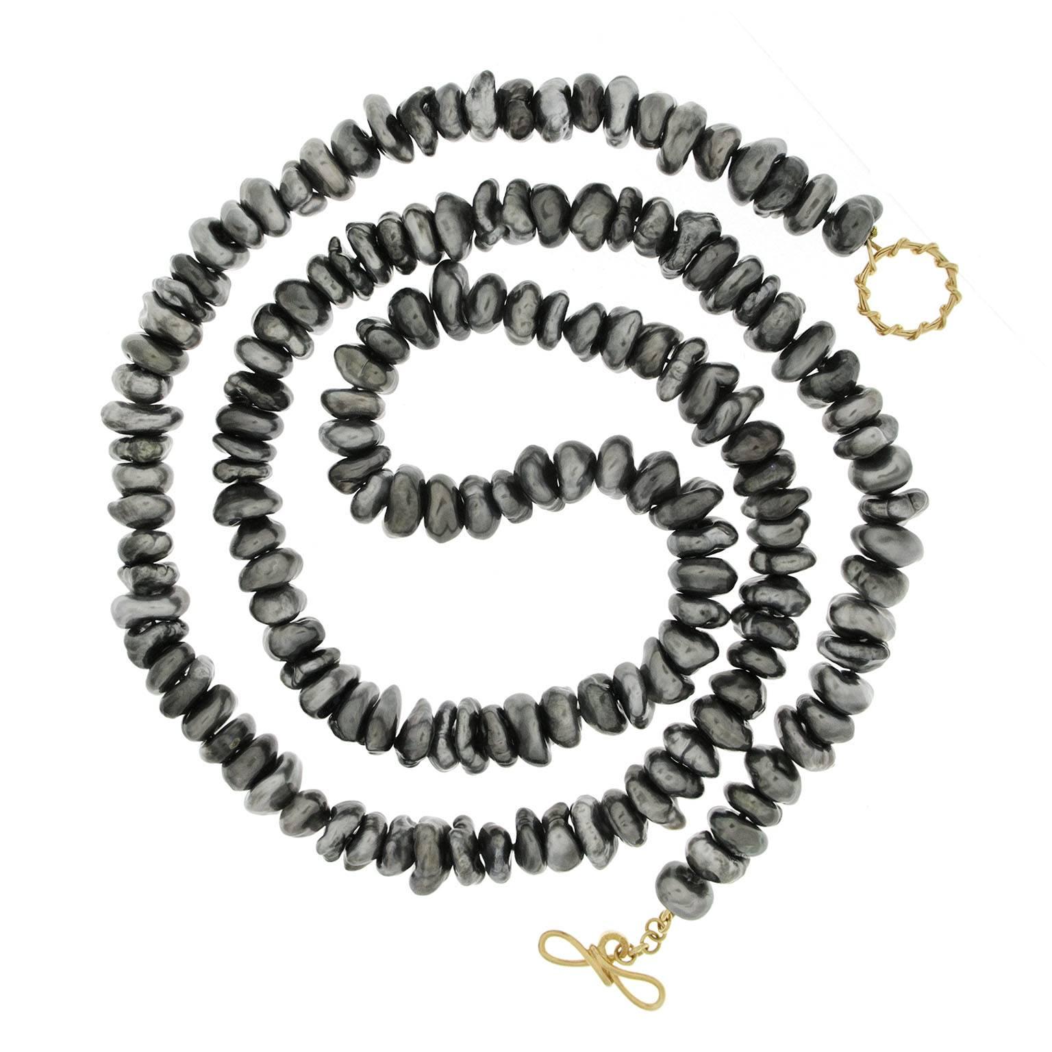 This unique necklace features a 36'' long single strand of Tahitian Keshi Pearls. It is finished with wire knot toggle clasp in 18kt yellow gold. So versatile that It can be worn as a long necklace or double up for a different look.