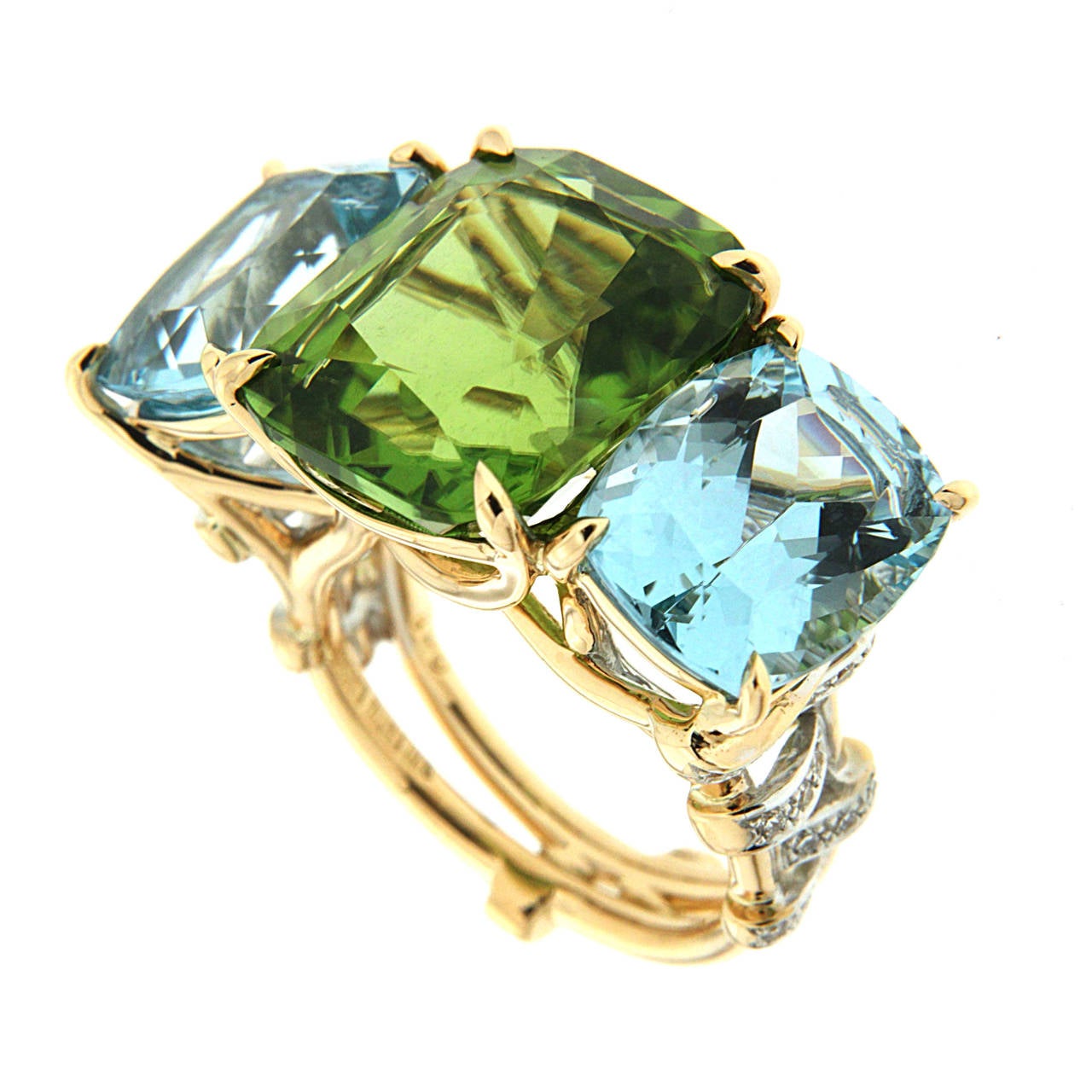 This ring features 10.59ct Cushion Peridot Center and aquamarines as side stones. The shank has diamond straps as decorations. This ring is made in 18kt Yellow Gold.