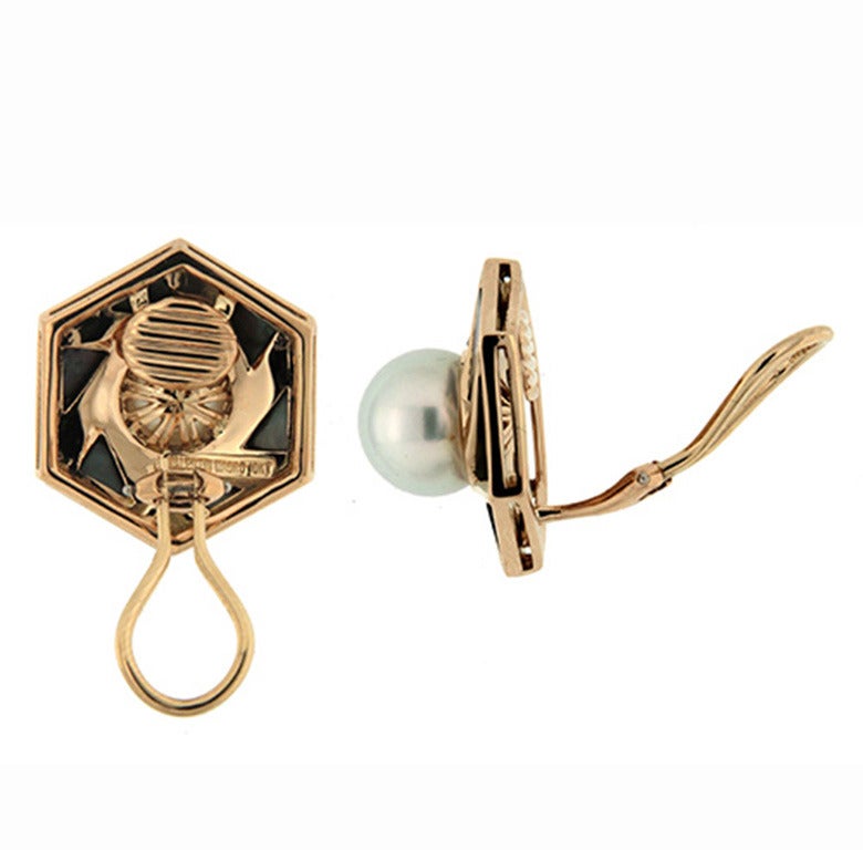 These earrings feature a white pearl in the center and gray mother of pearl, they are made in 18kt  yellow gold and are complete with clip-backs.