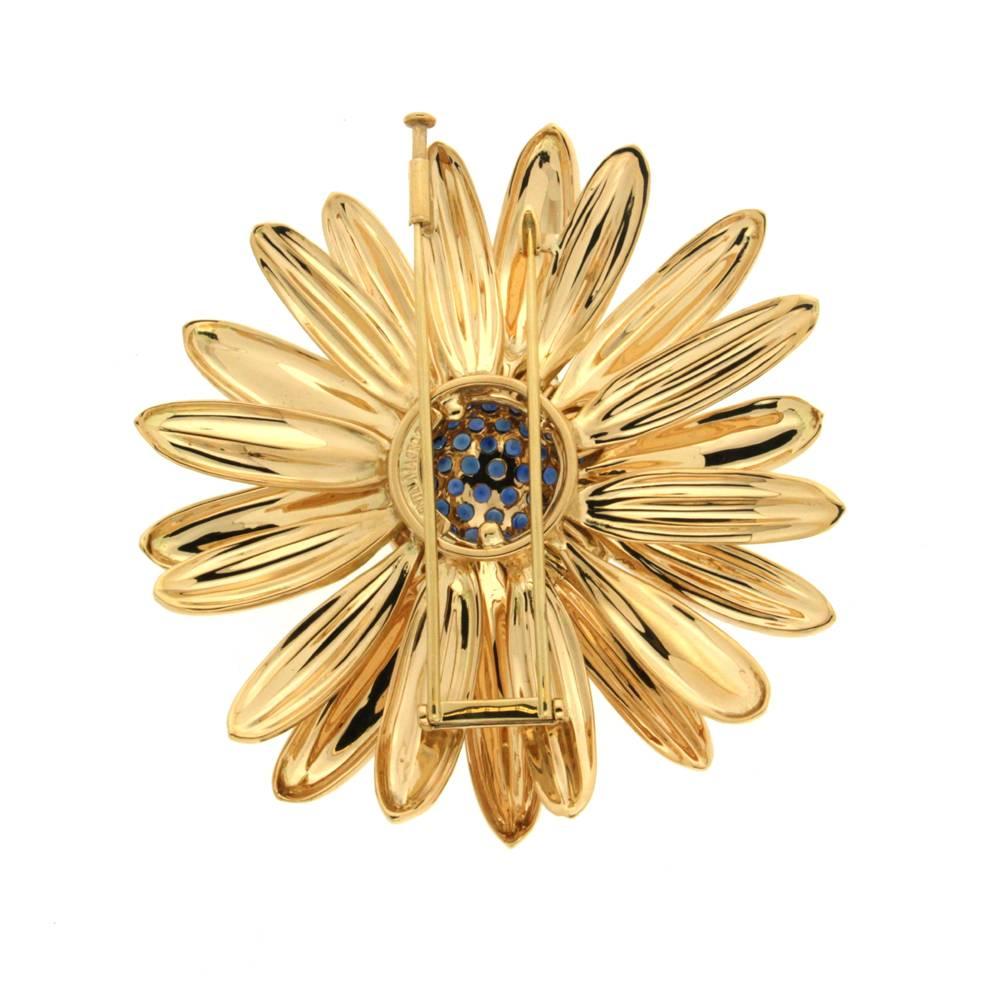 This lovely Daisy brooch with sapphire center is finished in 18kt yellow gold.