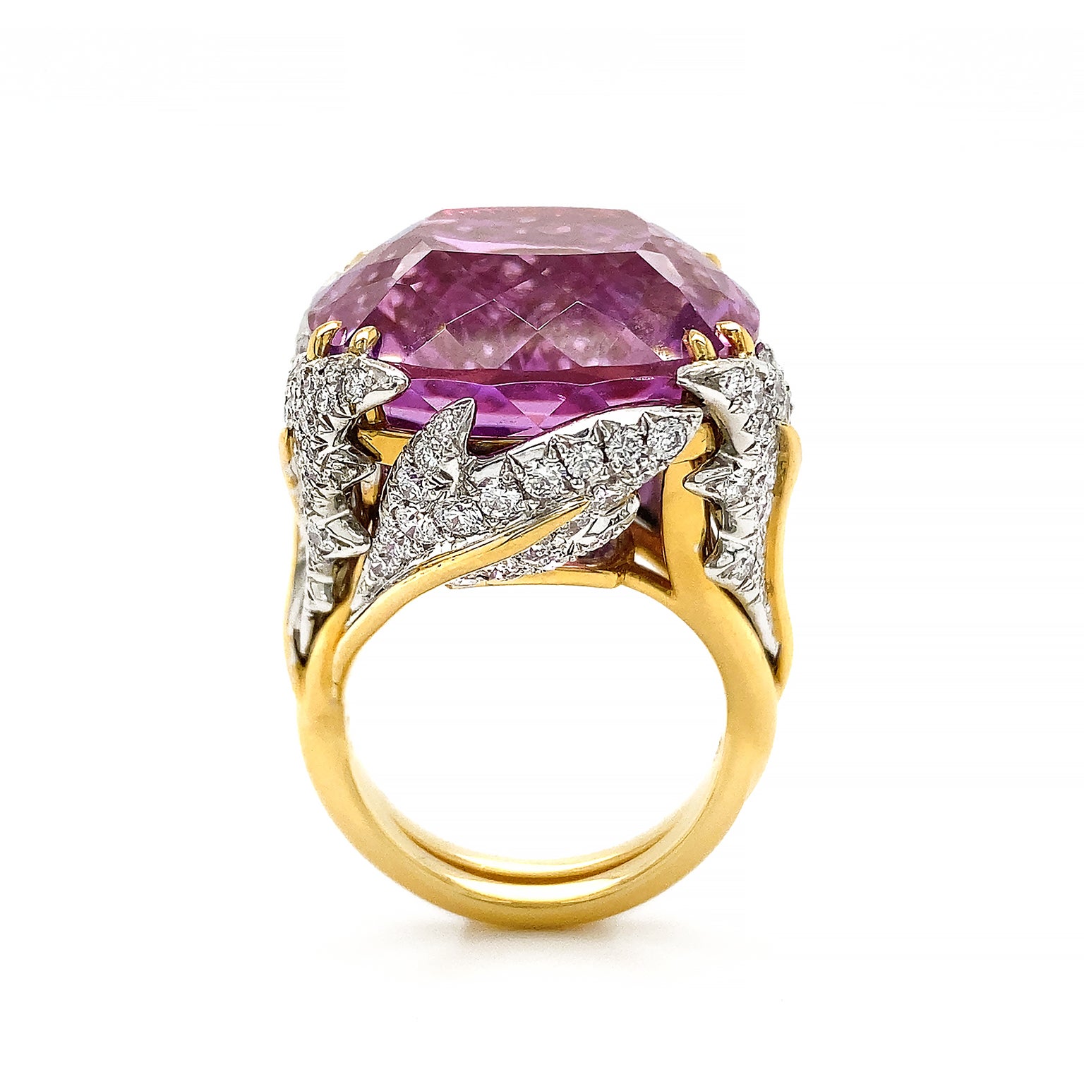 Kunzite glisters as the apogee of this ring. The unheated American-mined jewel has a vivid medium tone. Varied hues of purple and pink are lifted by the cushion cut with a strong pavilion. Platinum leaves adorned with brilliant cut diamonds overlap