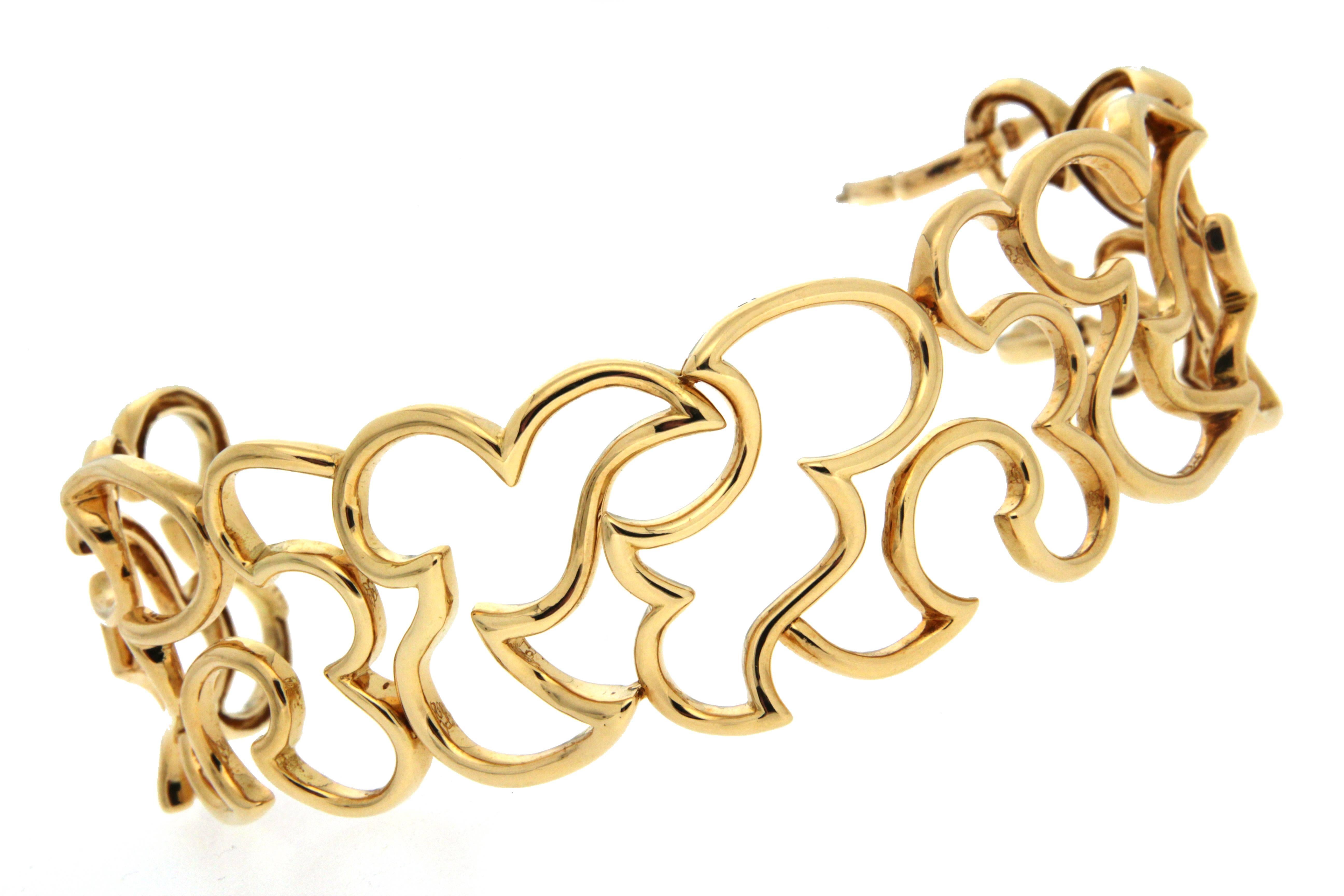 This  scroll bracelet with irregular shape and patterns is completed in 18kt yellow gold.