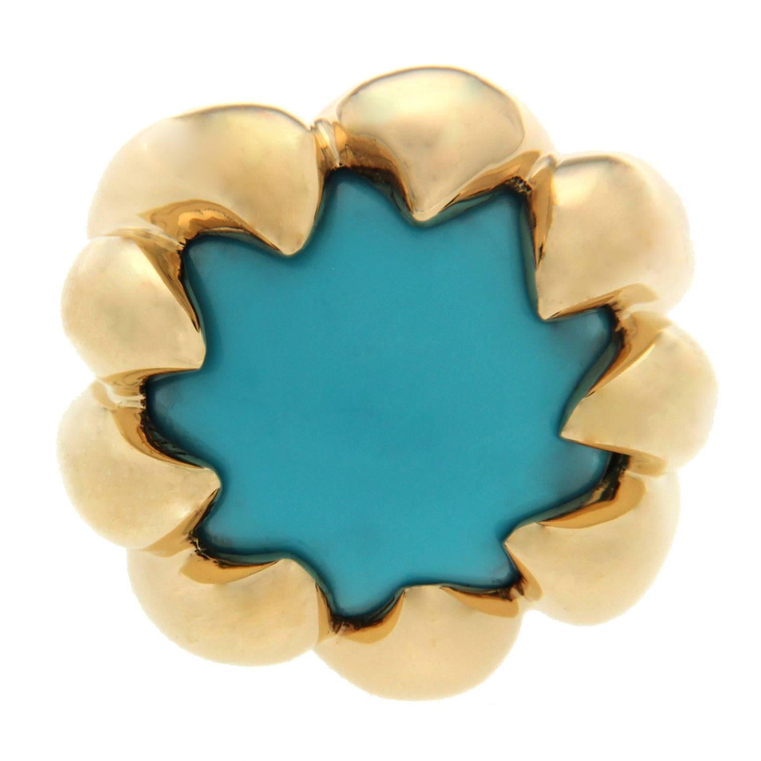 The ring is made in 18kt yellow gold and features a turquoise cabochon center stone. 