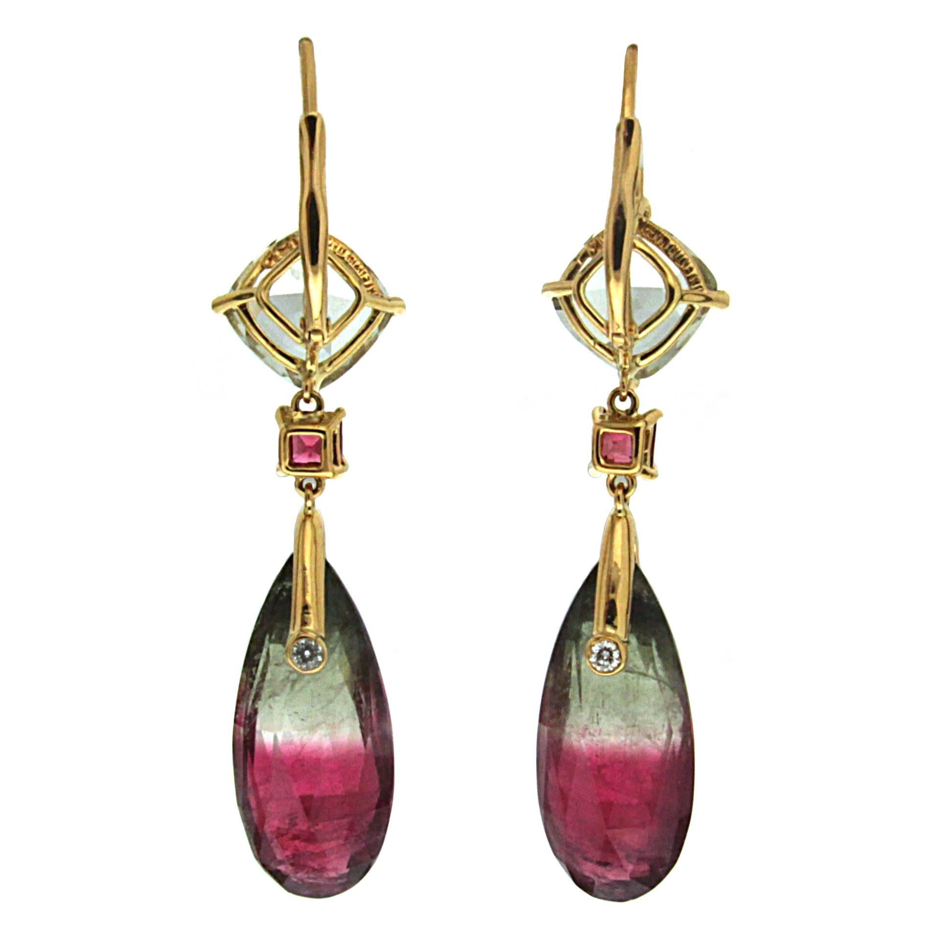 This pair of unique earrings feature Cushion Beryl top and square Rhodolite centers with Bicolor Tourmaline drops and four round brilliant diamonds. The earrings are finished in 18kt yellow gold and lever back.