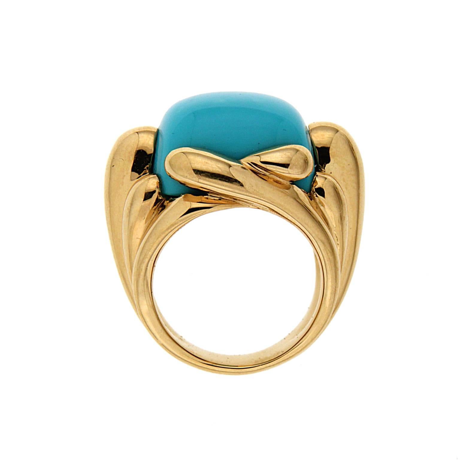 This ring is made in 18kt yellow gold, it features a cushion cabochon turquoise center which measures 16.5x13.65mm. 
