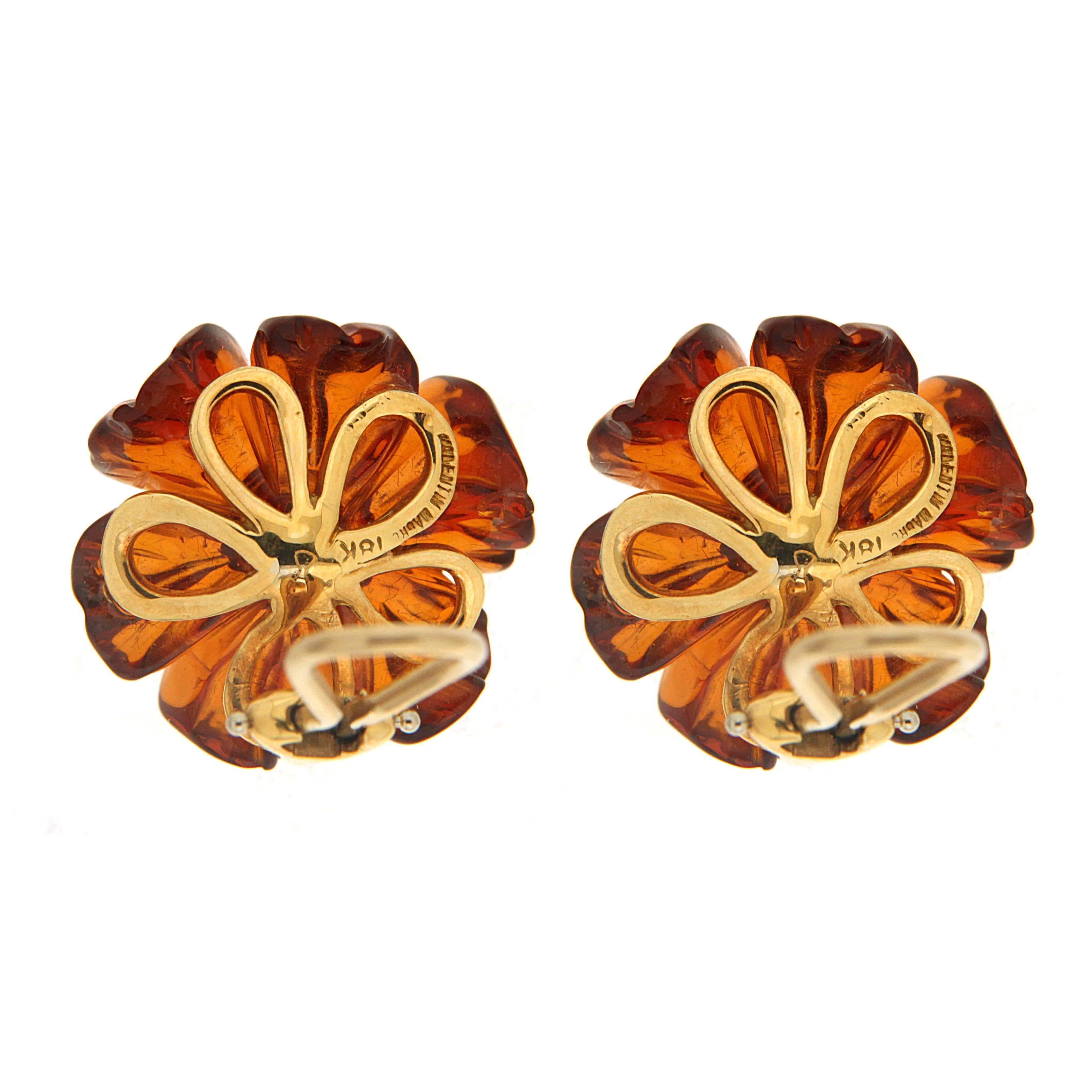 This unique pair of earrings features 20mm amber flowers with round Sapphire Cabochon in the center. The earrings are completed in 18kt yellow gold with clips. Posts can be added as requested.