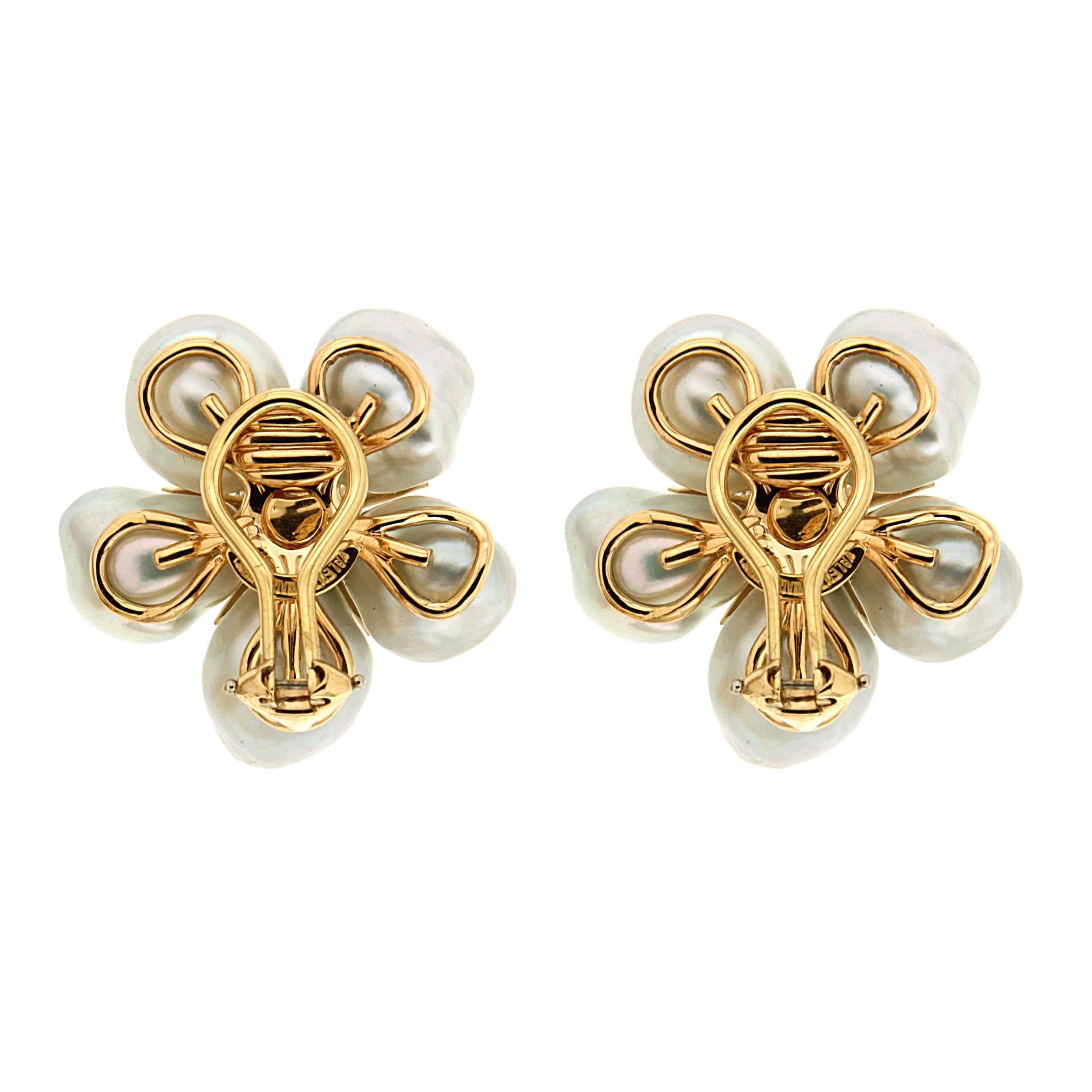 These earrings sparkle in an enchanting design inspired by nature's captivating flower. They are made in 18kt yellow gold, with white keshi pearls cluster and diamonds in the center, they are finished with clip backs. This delicate design marries