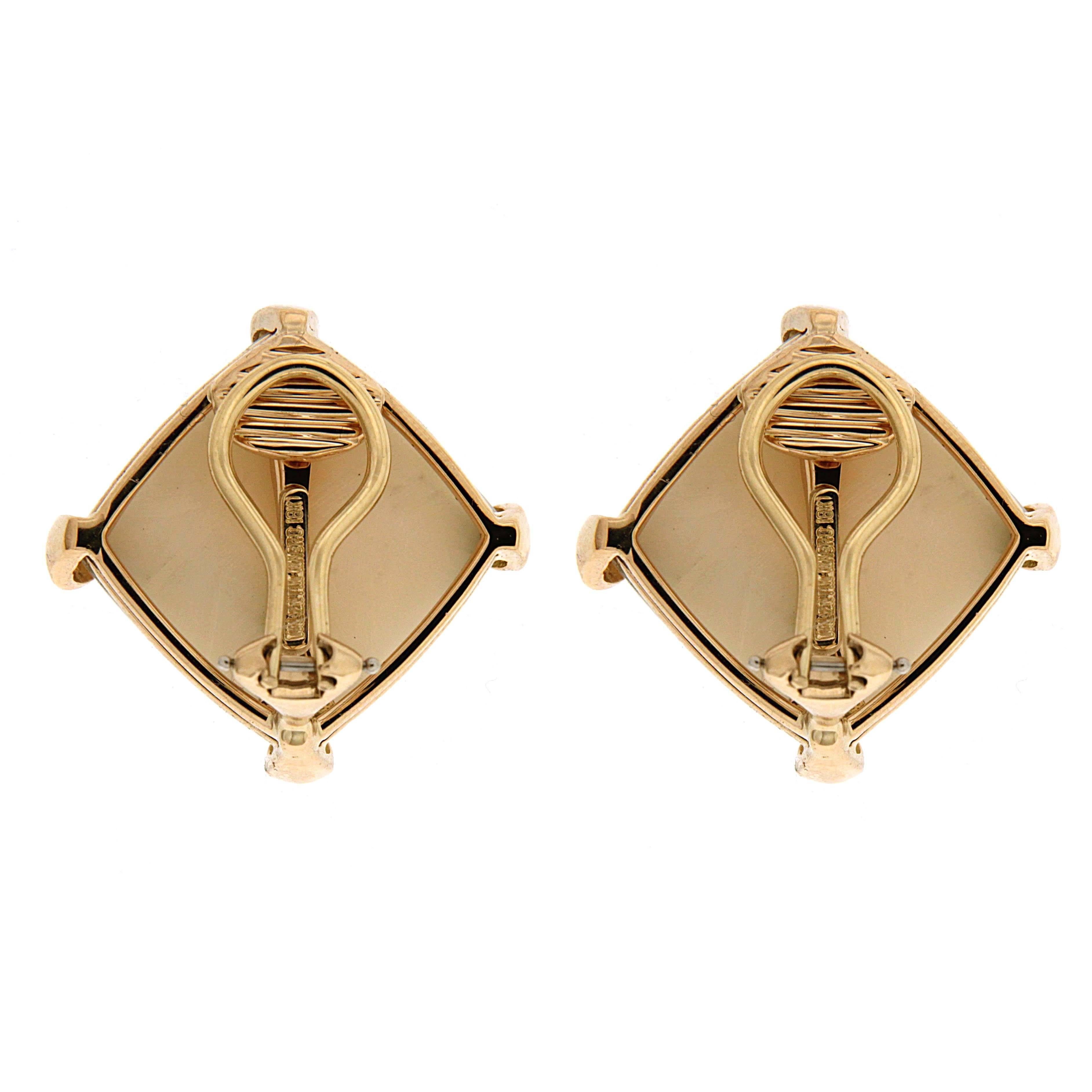 Cushion white coral button earrings with corner claws in 18kt yellow gold. The earrings are finished with clip backs.