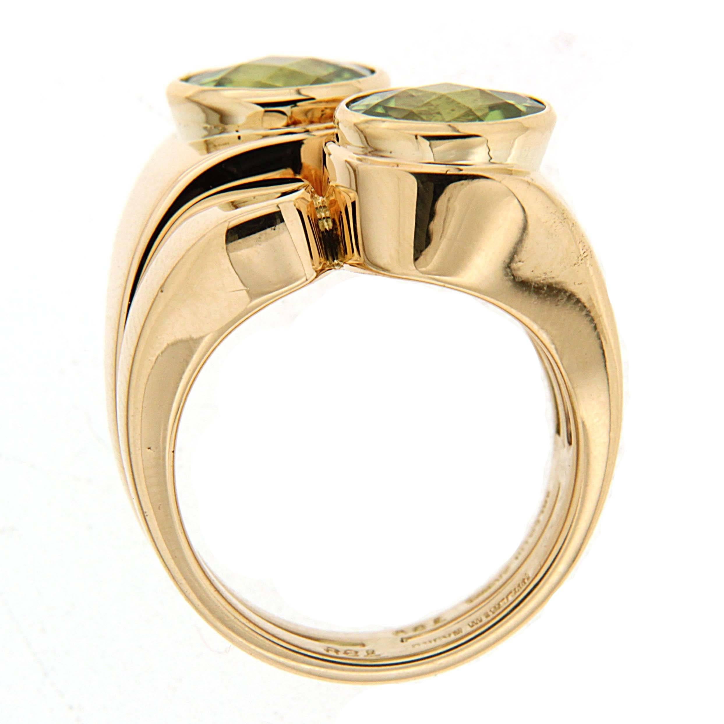 One of the most unique jewelry designs, this ring is made in 18kt yellow gold in asymmetric design, it features two 8.5mm round faceted peridot stones that match perfectly in color and shades, resulting in a perfect marriage of glamour and elegance.