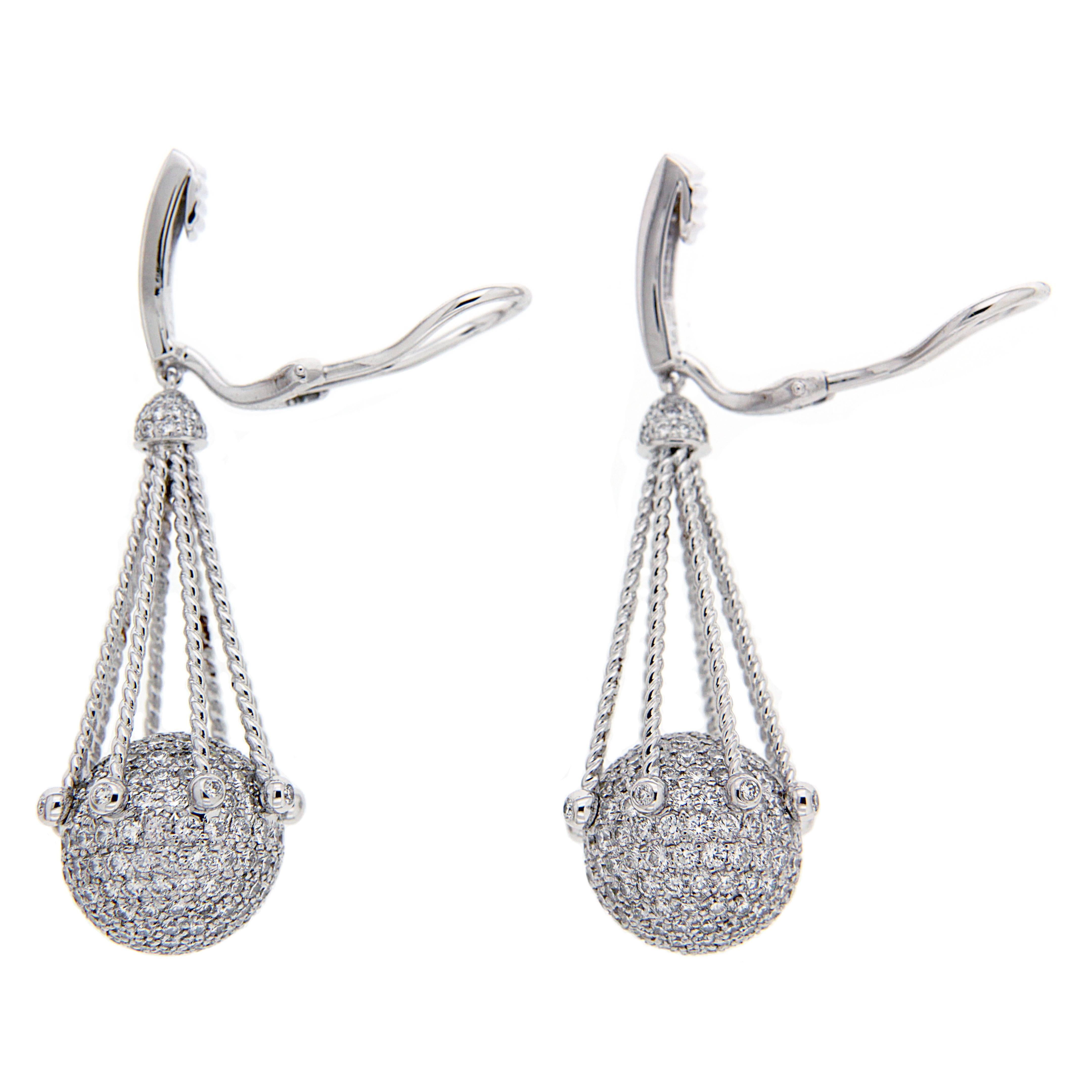 This elegant pair of earrings features pave balls with diamonds and twisted ropes accents. The earring is finished in 18kt white Gold with clip backs. Diamond total weight 6.90ctw