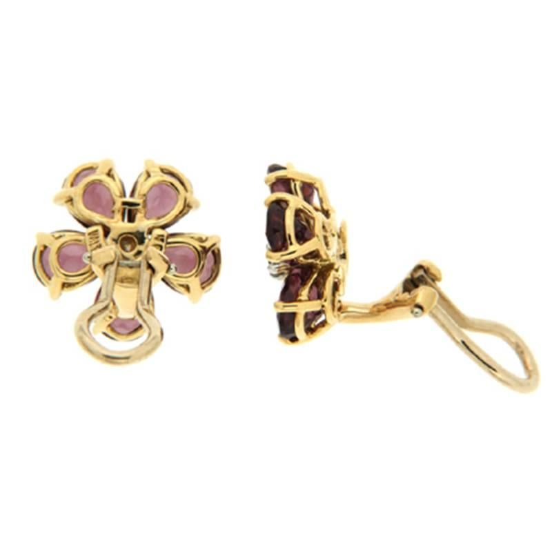 These earrings are made in 18kt yellow gold, they feature pear shape rhodolite garnet stones and a round brilliant diamond in the center, they are finished with clip backs. 