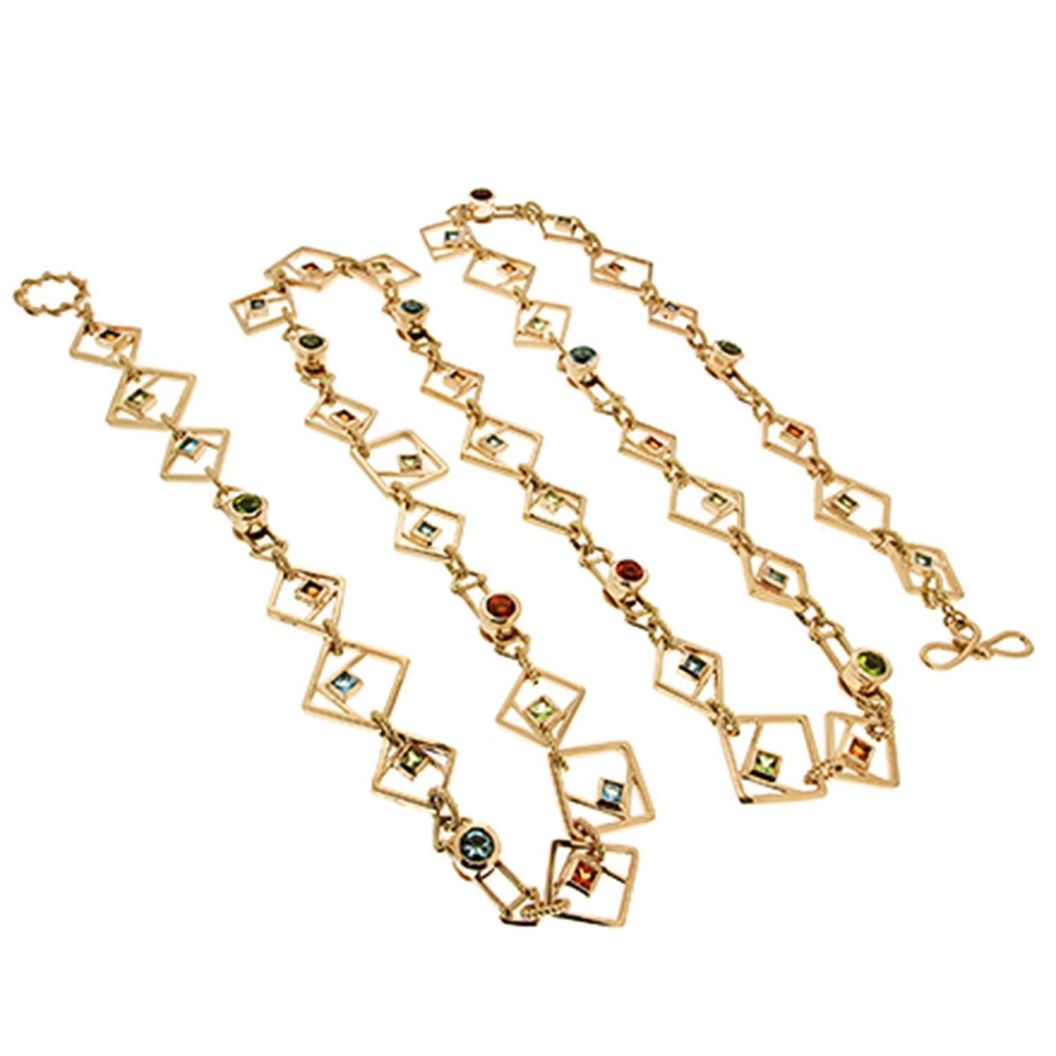 This unique necklace features geometric square shapes and forms with the accents of expert selected faceted Peridot, Blue Topaz and Citrine stones in various shapes and sizes. The necklace is finished in 18kt yellow gold with our signature ring and