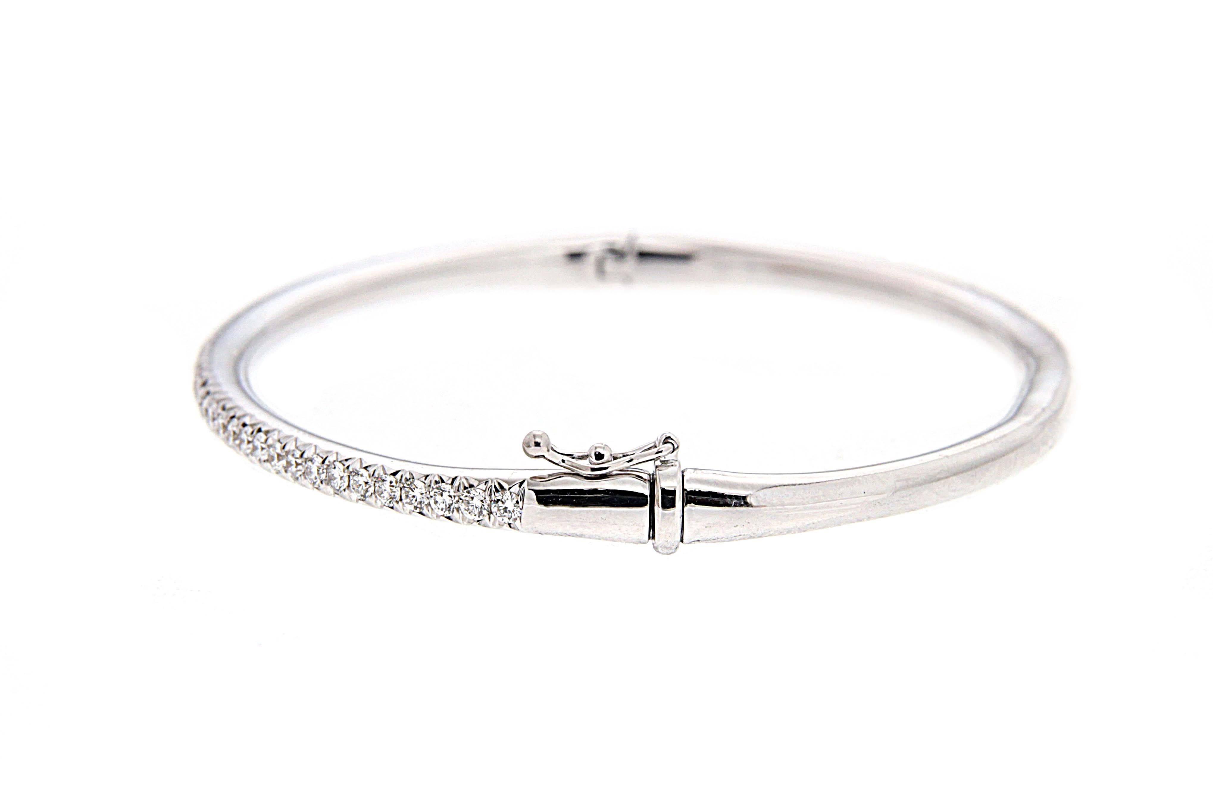 This elegant bangle features a single line of pave diamonds that goes half way around the bangle, total weight 1.08ctw in 18kt white gold. (DEF/VVS) 
The result is a unique jewel and the perfect gift for any occasion.