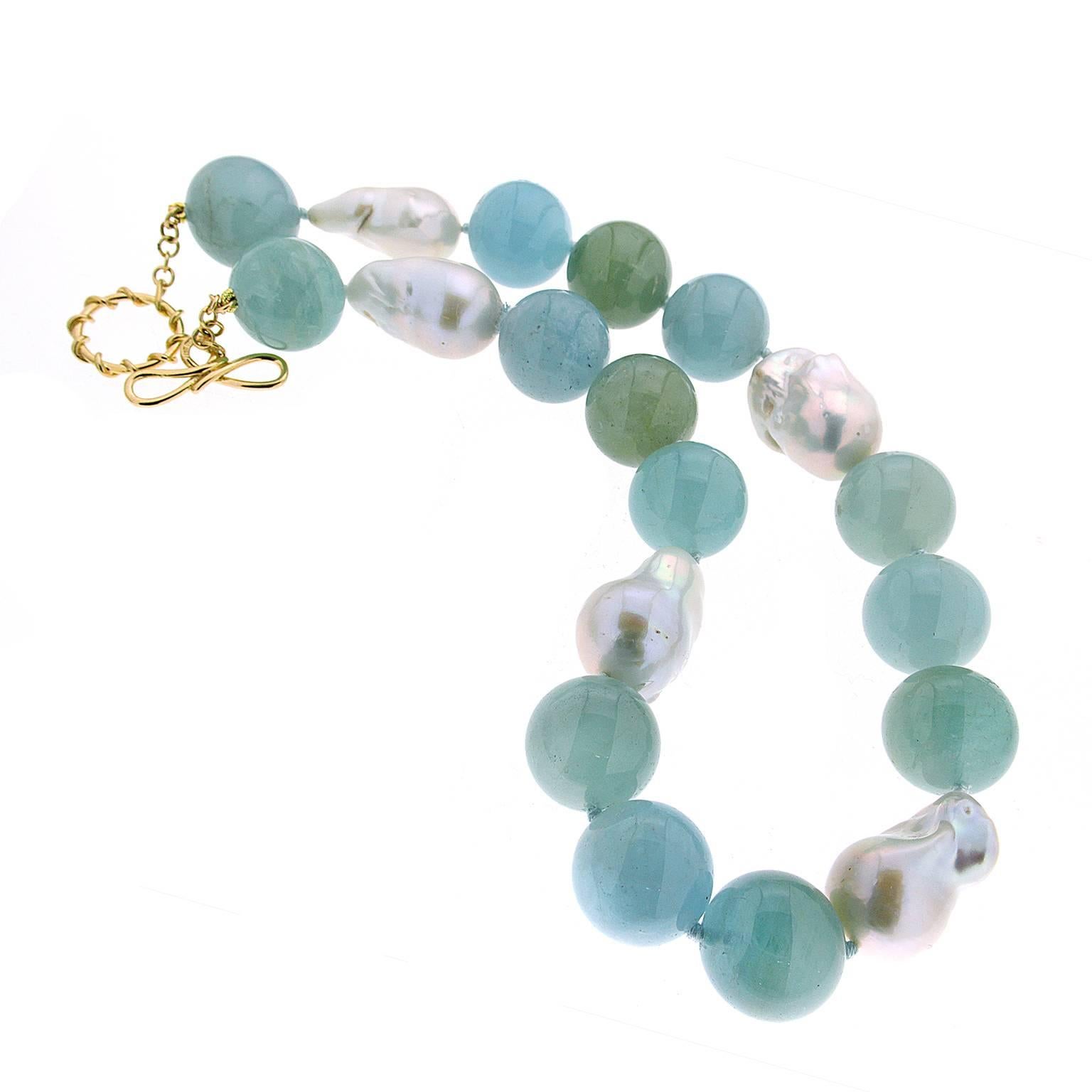 This unique necklace features 20mm aquamarine ball (14) in blue / greenish blue and freshwater pearls with 18kt yellow gold ring and toggle.