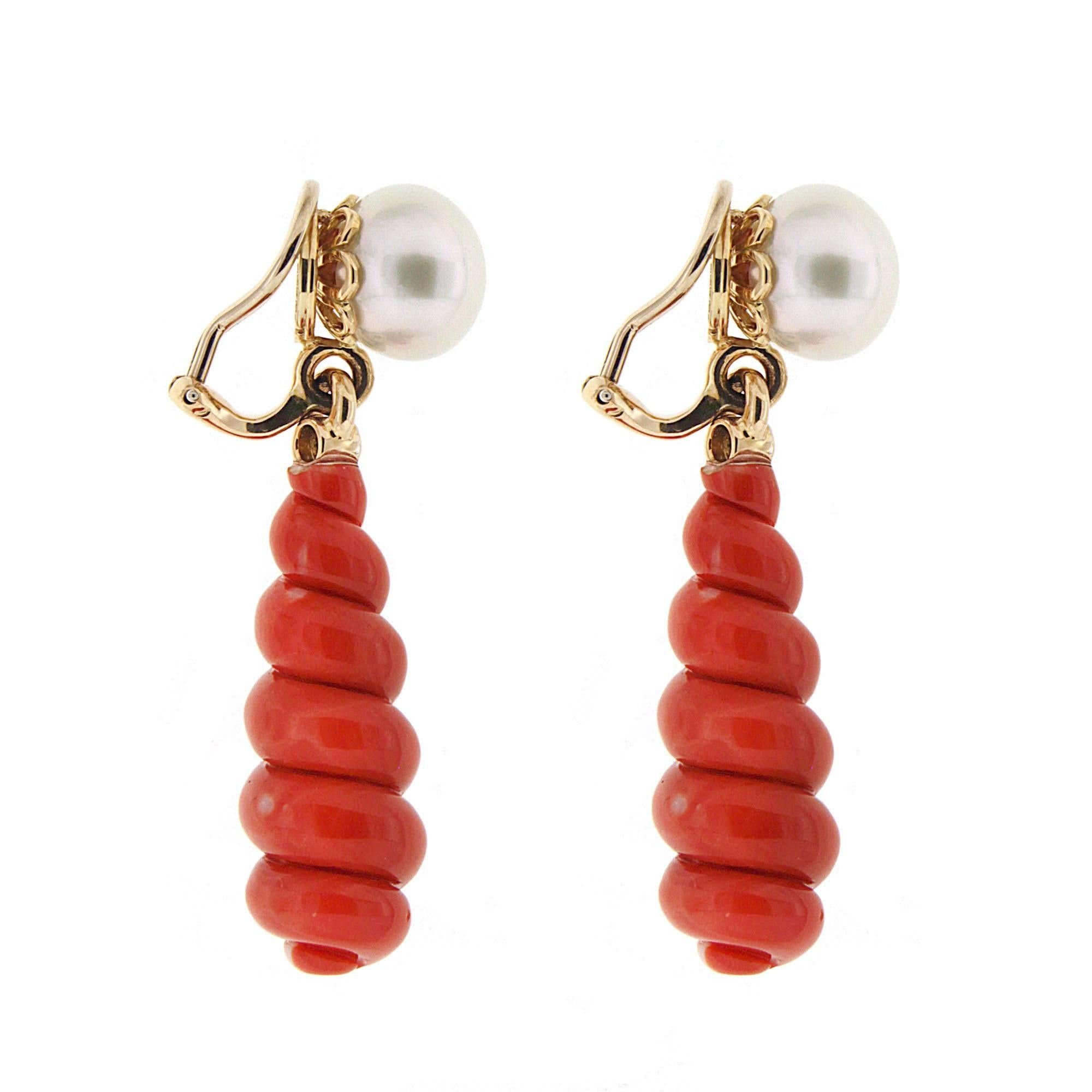 This unique pair of 12.3mm round freshwater pearl top with special cut spiral red coral drop earrings with accent bezel set round brilliant diamond connectors. The earrings are made in 18kt yellow gold with clip backs.

Diamond total weight is