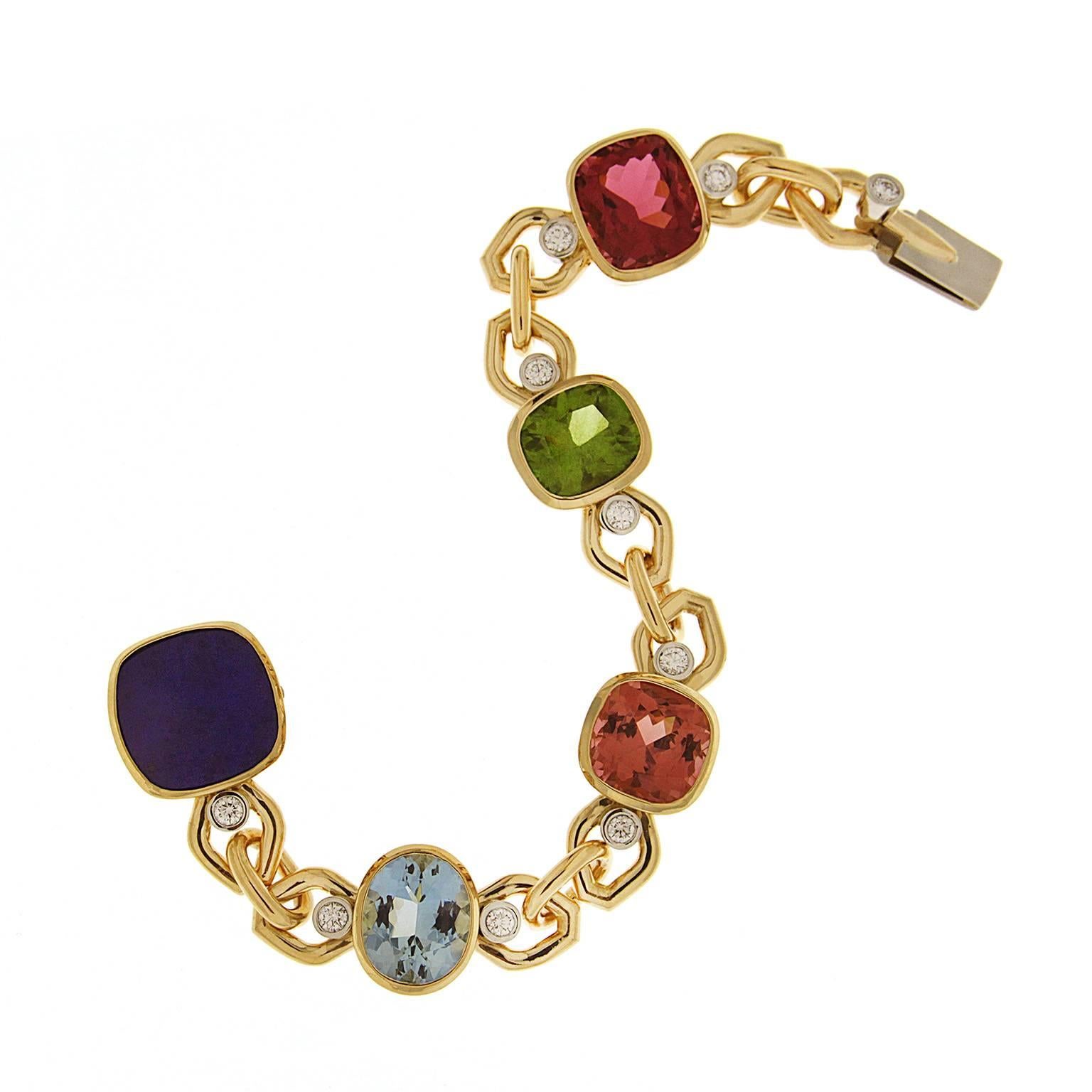 This unique multi color stone bracelet has an oval shape Aquamarine, cushion Lapis Lazuli, Cushion Pink and Brown Tourmalines and a cushion Peridot connected with bezel set diamond links in 18kt yellow gold. 
