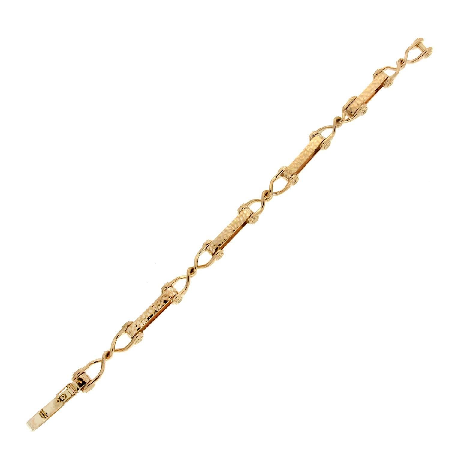 This unique and simple bracelet features 5 double textured bar jointed with wire knot in 18kt yellow gold.