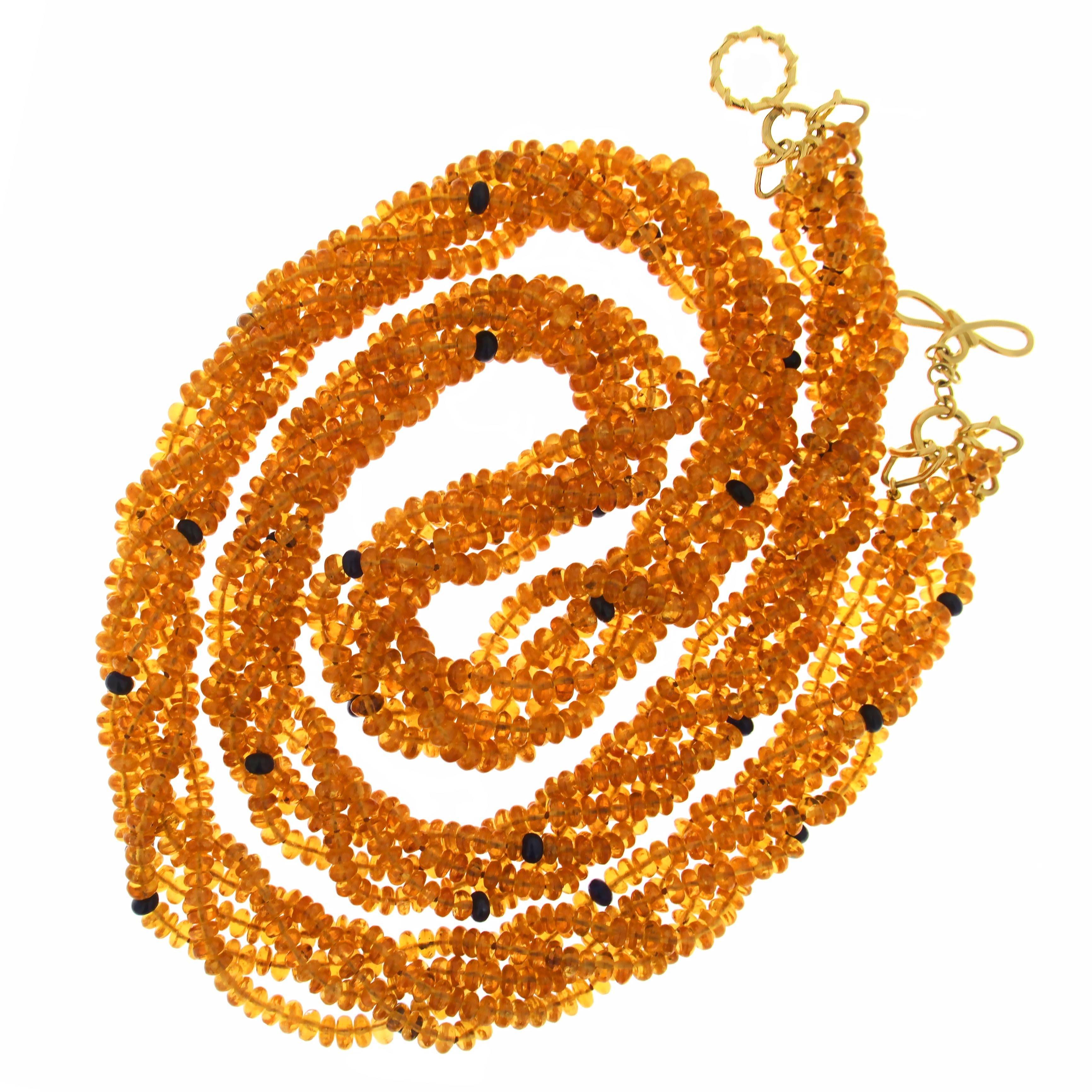 This unique necklace features five strands of mandarin garnet and sapphire rondelles with signature knot ring and toggle in 18kt yellow gold. 