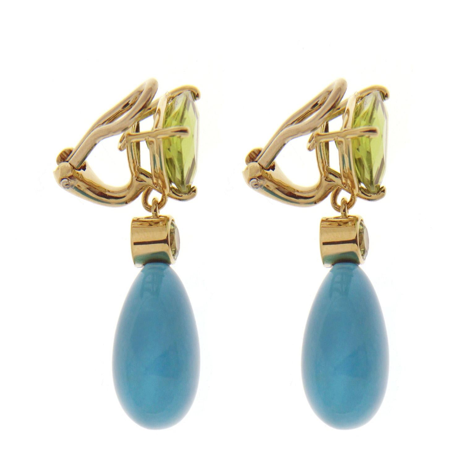 Green and blue enliven these drop earrings created by Valentin Magro. Their base is 18 yellow gold supporting a trilliant peridot with curved sides. Emerging from the bottom most point is a gold ball, bezel set peridot and a turquoise cabochon. The