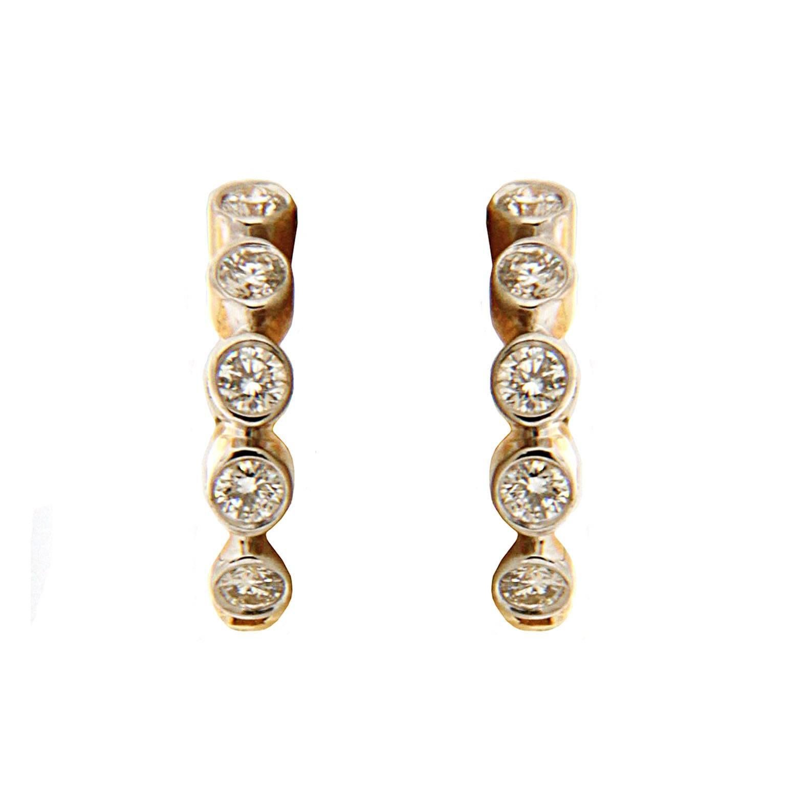 These hoop earrings are made in 18kt yellow gold they feature 0.24 carat total weight of round brilliant diamonds.