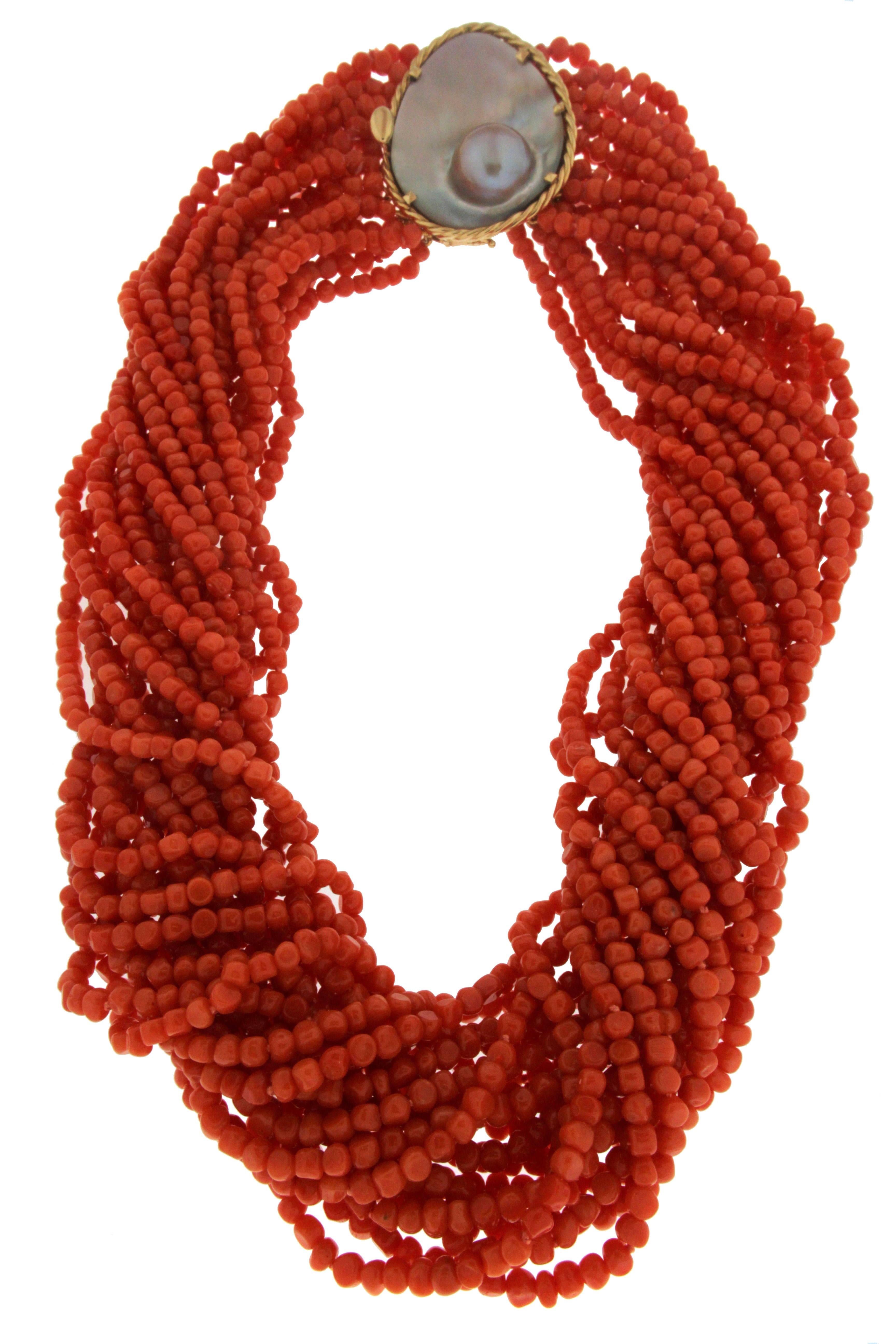 This one of a kind necklace features 19 strands of small nugget shape dark orange coral, half moon blister pearl clasp with 18kt gold frame.
