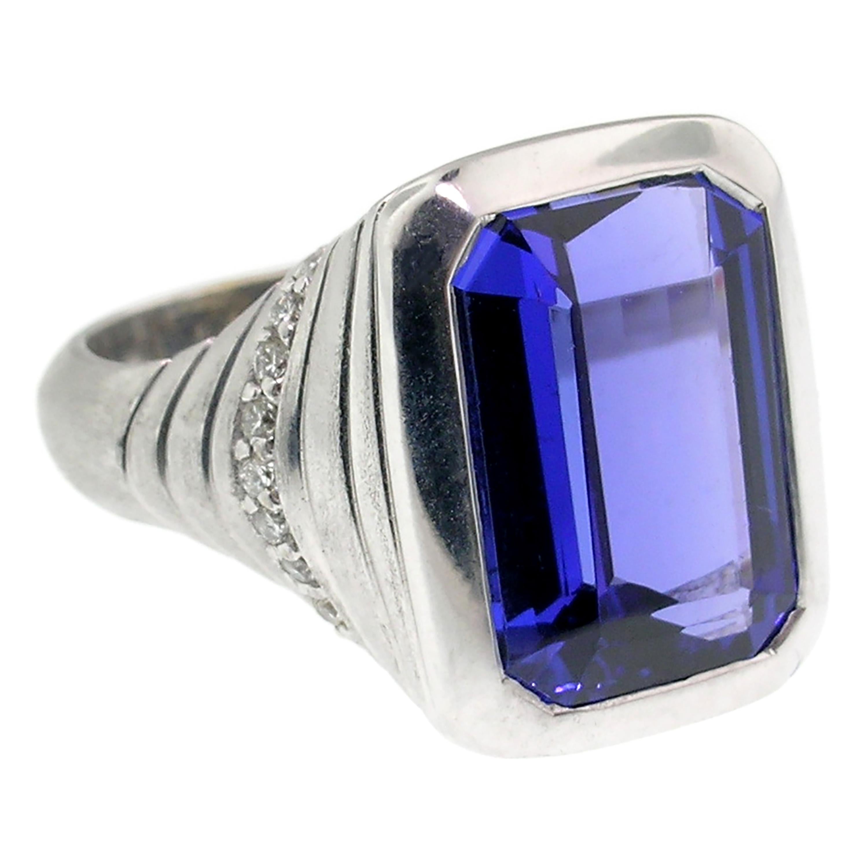 This 7.29ct emerald cut tanzanite is a lovely example of the material with a gorgeous and saturated color. This classic pleochroic gem shows rich blue, gorgeous violet, and flashes of red fire.

This beautiful custom 18kt white gold ring is clean