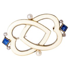 Spilla d'epoca Cartier in stile Art Déco con zaffiri e smalto a forma di cuori intrecciati