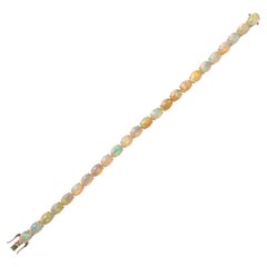 Bracelet « tennis » en opales éthiopiennes flamboyantes, cabochons ovales de 20,24 carats, or 14 carats