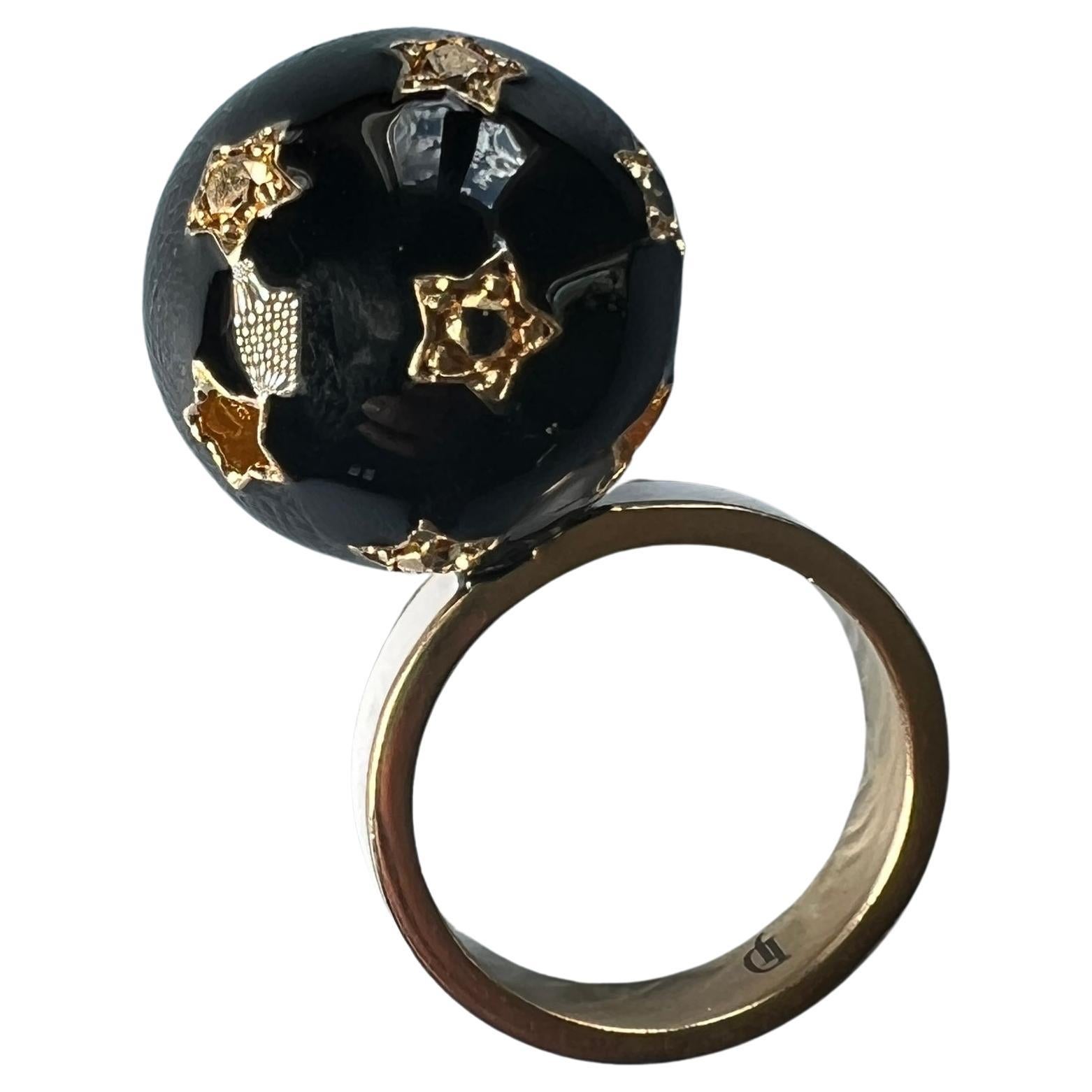 Sfera con diamante nero e diamante bianco Anello con placca d'oro 14k e smalto nero La base è realizzata con smalto bianco.  

Anello con smalto nero, ispirato all'epoca vittoriana, Memento Mori

Progettista: J Dauphin

La sfera come simbolo
