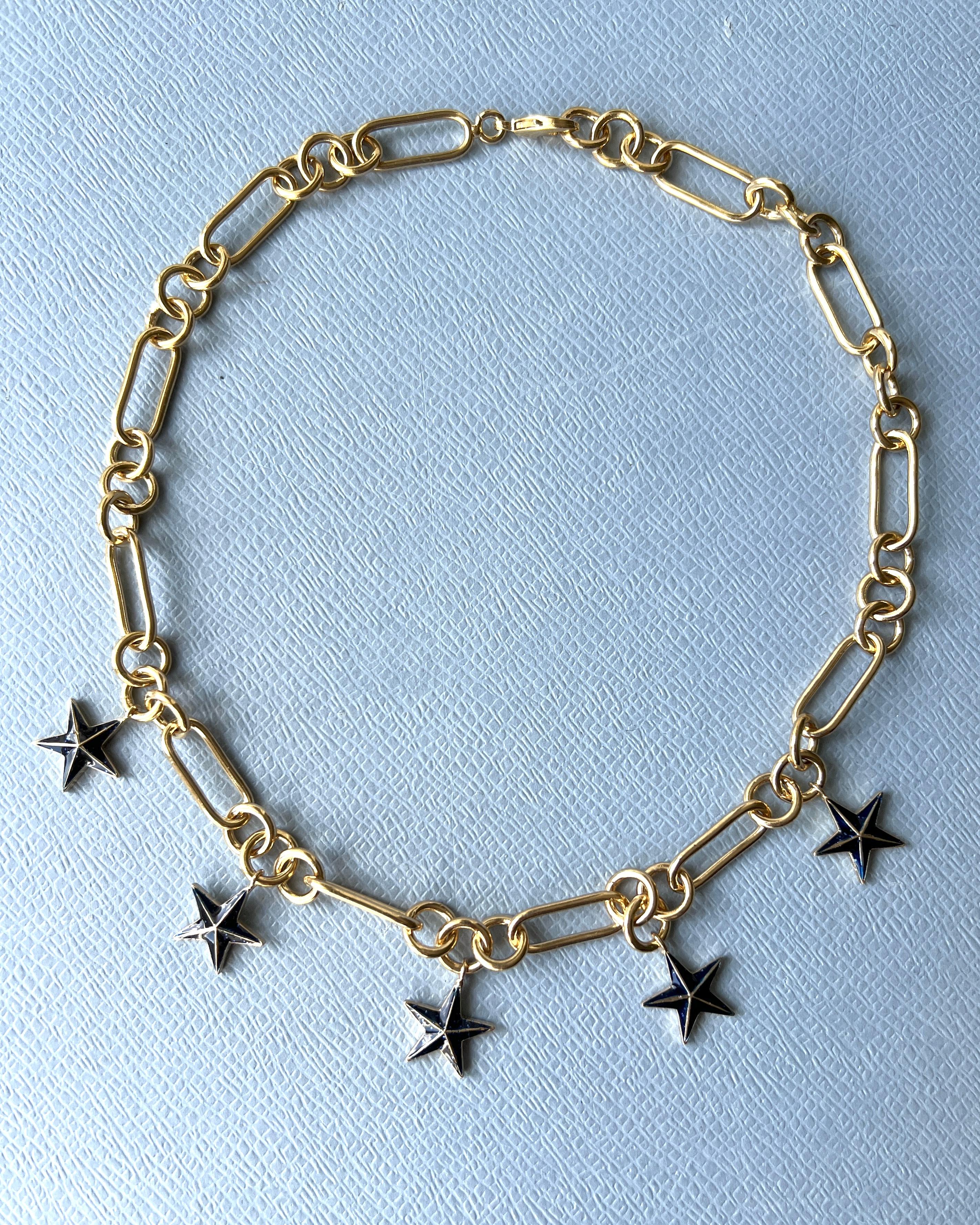 Collar Estrella Cadena Gargantilla Chapado en Oro de 14k y Esmalte Azul Noche.

Diseñador: J DAUPHIN 

La estrella de cinco puntas, a menudo conocida como pentagrama, encierra un importante simbolismo espiritual en diversas tradiciones y creencias.