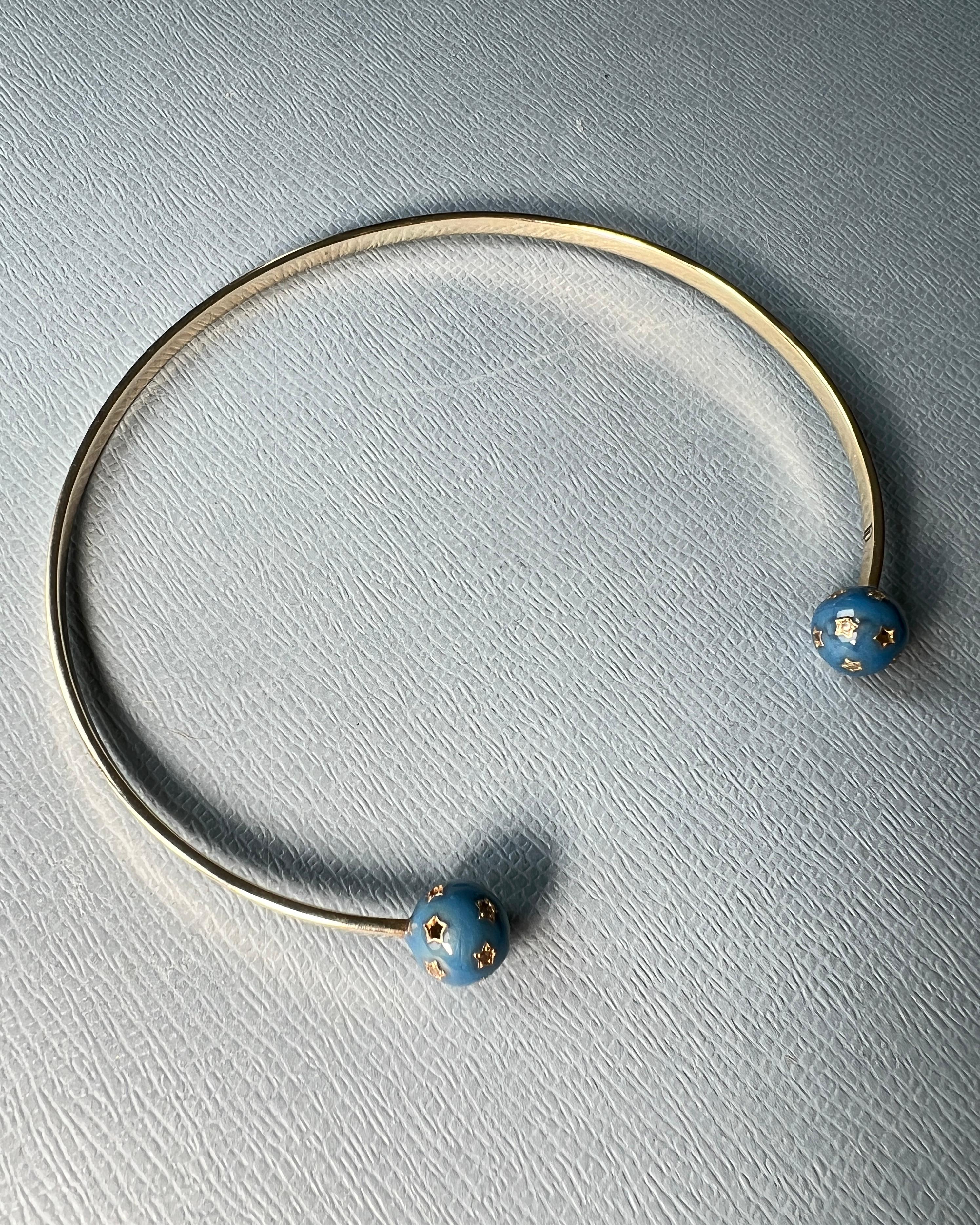 Questo braccialetto da collo simbolico di J DAUPHIN presenta due sfere scultoree all'apertura anteriore, ciascuna ricoperta di smalto blu smaltato a mano e con diamanti naturali bianchi e neri incastonati in incisioni a forma di stella. Il design è