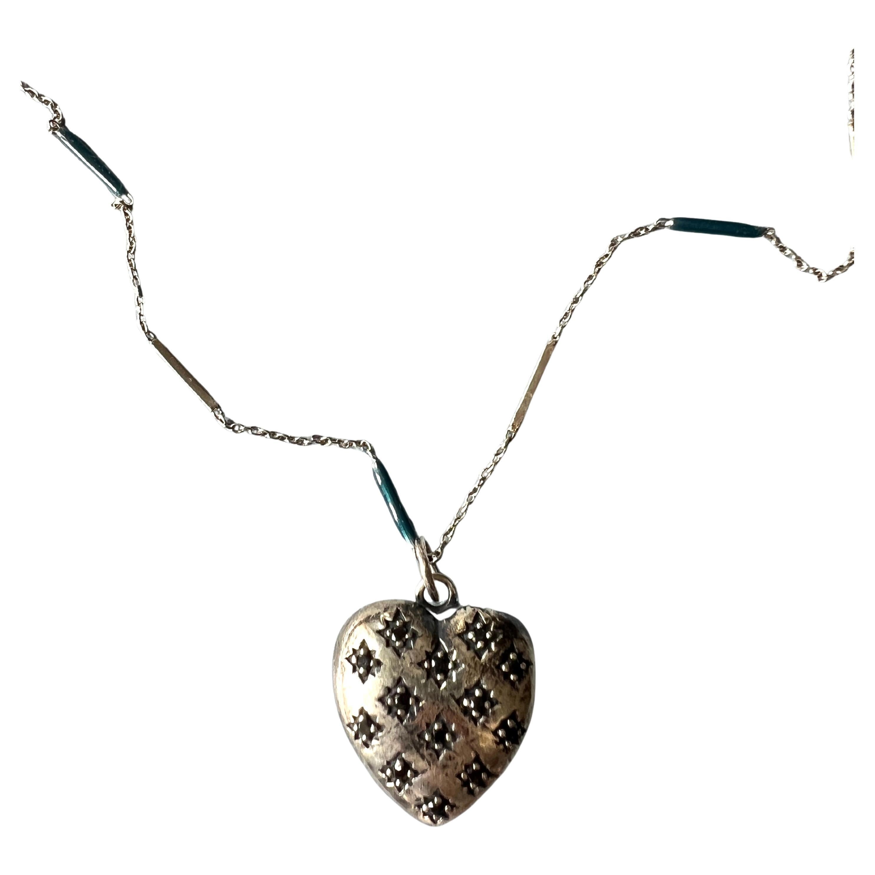 Questa collana simbolica di J DAUPHIN è caratterizzata da un ciondolo a forma di cuore in stile vittoriano realizzato in argento sterling e interamente tempestato di diamanti neri naturali. Sospeso da una catena d'argento di 28 pollici dipinta a