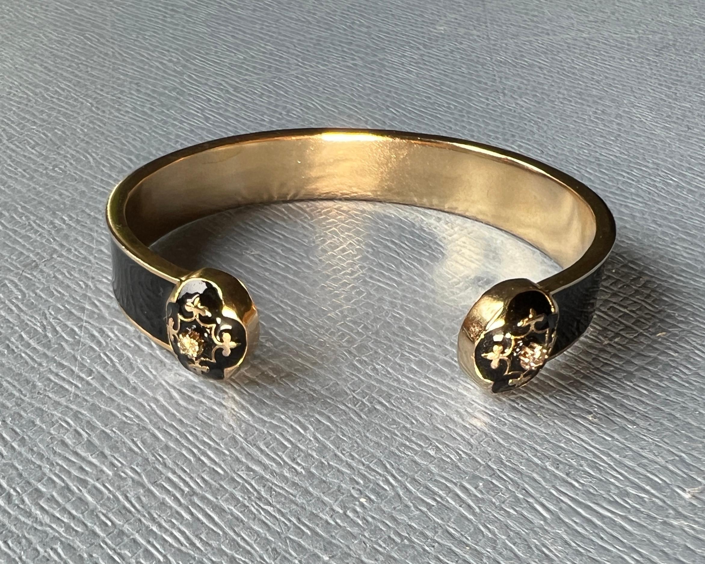 Pulsera de esmalte negro con flor de lis de diamante blanco y grabado infinito - Joyas espirituales bañadas en oro del diseñador J Dauphin

Esta llamativa pulsera brazalete está fabricada en latón chapado en oro de 14k, totalmente recubierta de