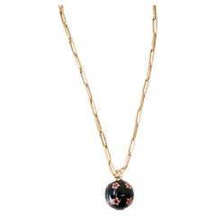 Collier avec sphère en émail noir, étoile en rubis et chaîne « paperclip » dorée