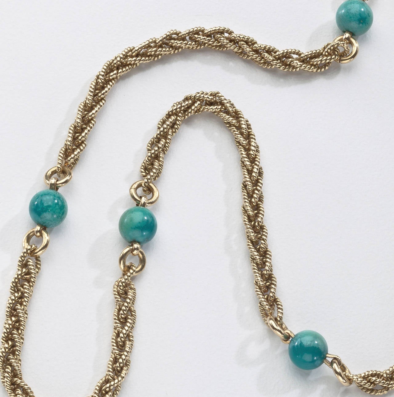 An 18 karat gold rope twist chain by Cartier accented with eight round turquoise spacers.  Signed Cartier Italy K18 with the inventory #2139.  The chain measures 24.25 inches long.