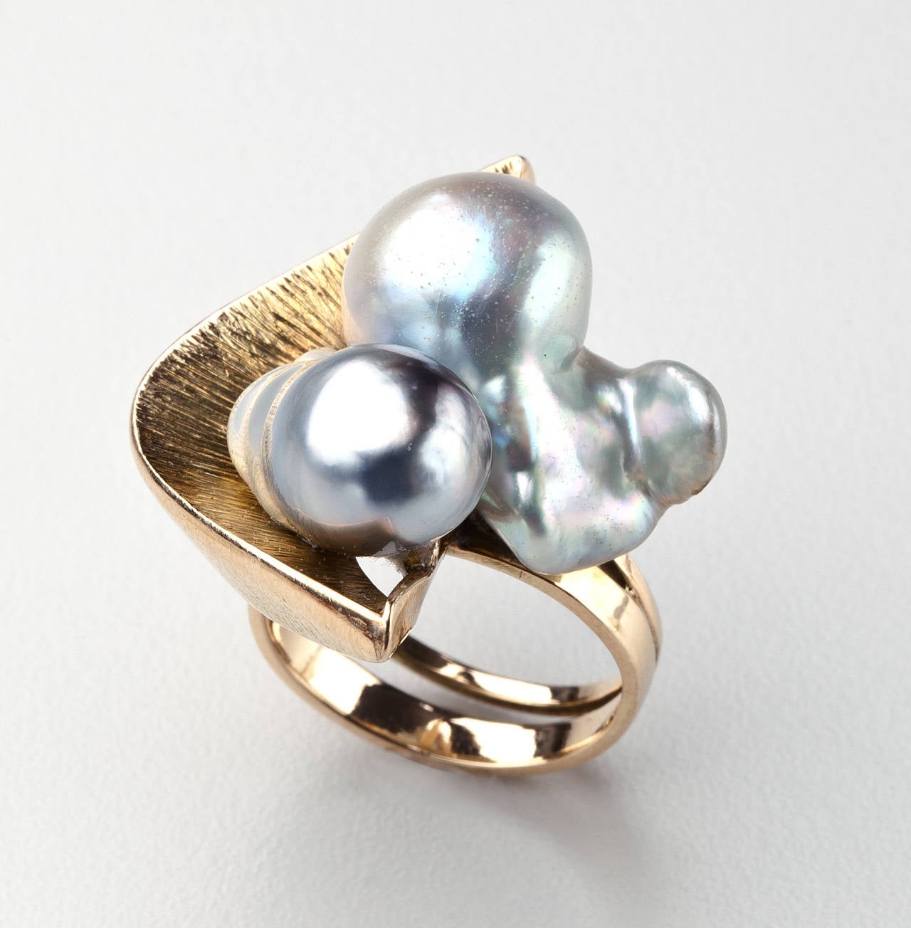 A 14 karat gold ring with two baroque pearls by Margaret de Patta (1903 - 1964).  De Patta, who worked in San Francisco, is considered one of the most influential designers of the modern jewelry movement.  She designed this ring with a textured gold