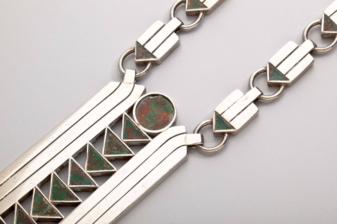 A rare sterling silver necklace by American/Mexican silver master William Spratling (1900-1967).  The necklace has a long central pendant shaped like an arrow with triangular stones and an incised sterling silver setting.  The chain is also a series