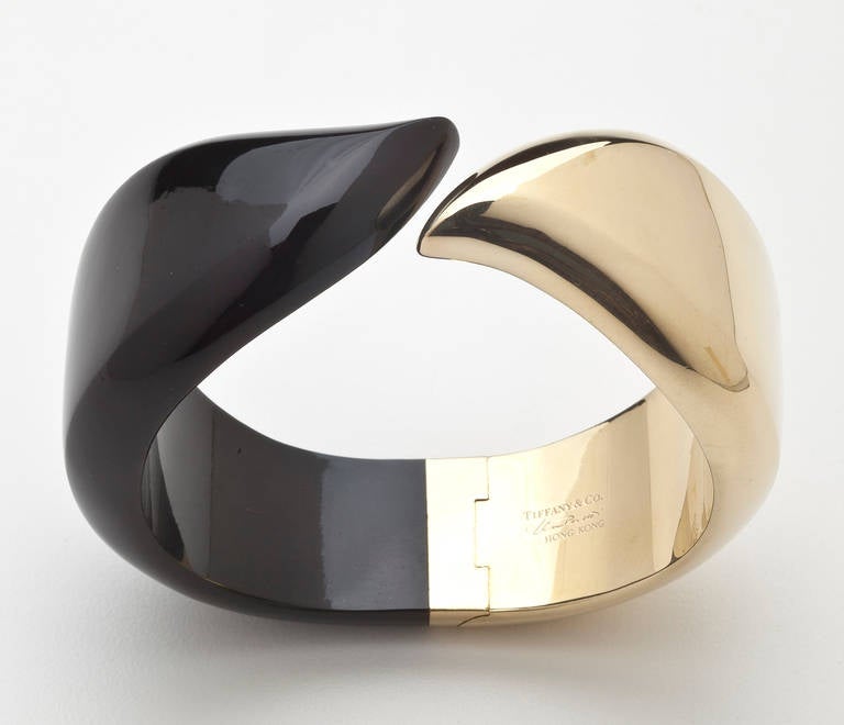 A gold and onyx bracelet in a winged design by Elsa Peretti for Tiffany.  The bracelet is divided into two hinged parts, one in 18 karat gold; the other in onyx to form a striking abstract and decidedly modern design.  Signed 