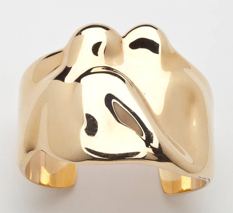 An 18 karat gold cuff bracelet by Elsa Peretti for Tiffany.  The bracelet is enhanced with an abstract design sculpted to show two figures or anything else the eye may perceive. It is especially suitable for a small wrist; having the added feature